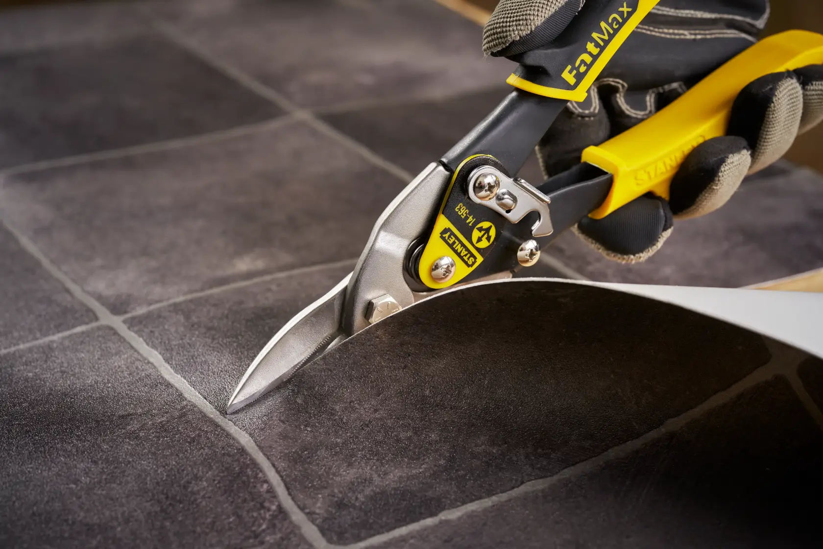 STANLEY 2-14-563 Blechschere mit gelbem Griff schneidet Fliesenplatte Nahaufnahme.
