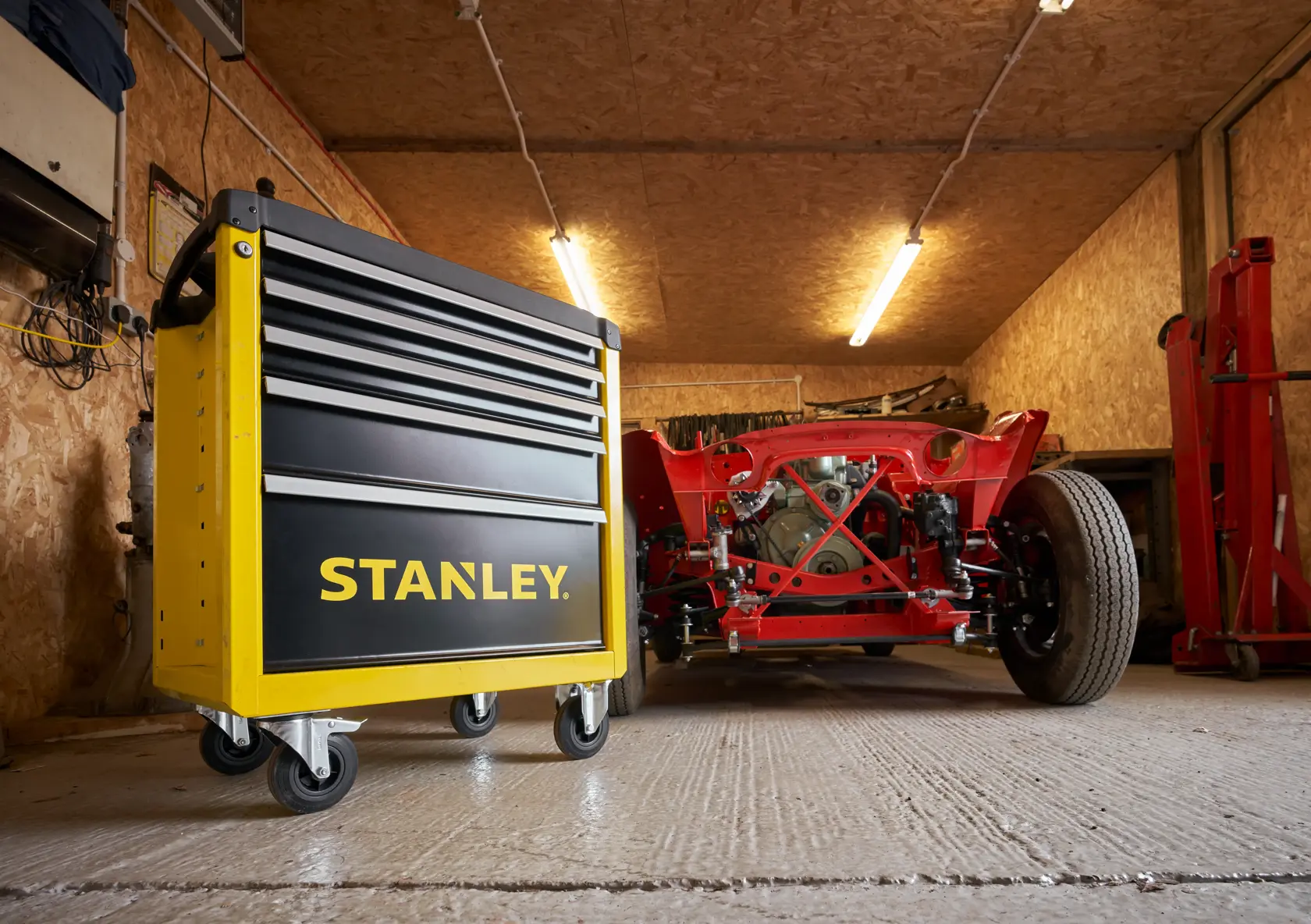 Foto des STANLEY STST74305-1 gelb-schwarzen fahrbaren Werkzeugschranks in einer Garage, Vorderansicht links.