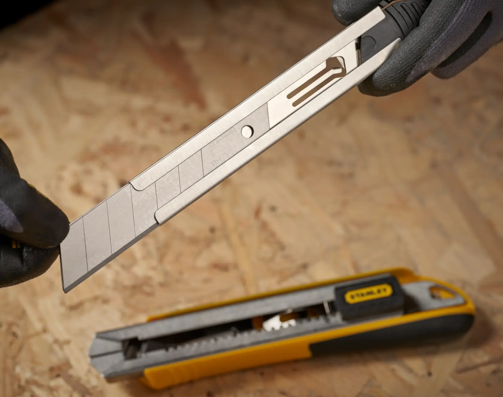 STANLEY 0-11-725 snap-off utility knife blade close-up, showing segmented blade and yellow handle.