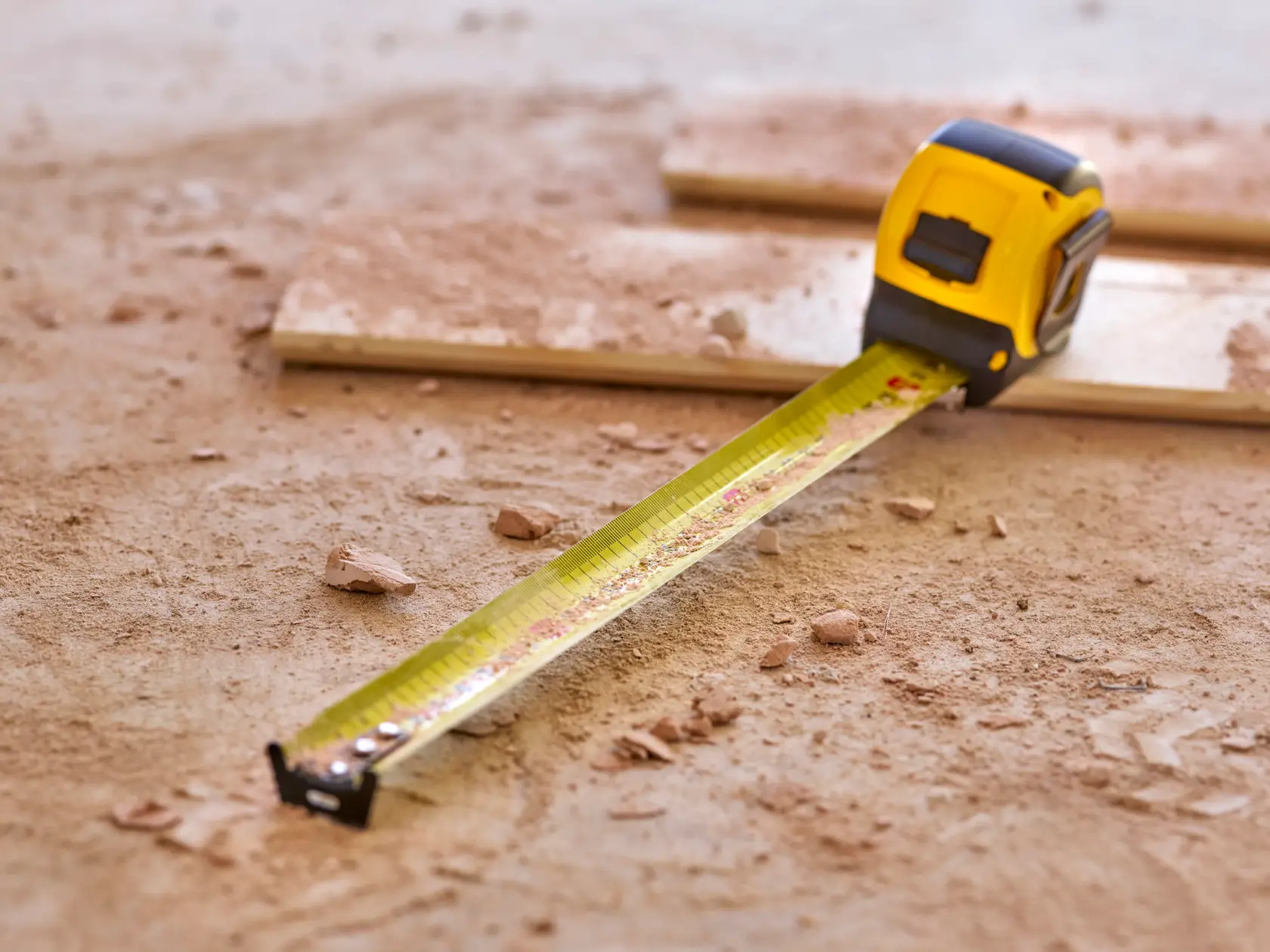 STANLEY 0-33-720 tape measure extended on dusty construction floor, photography product.