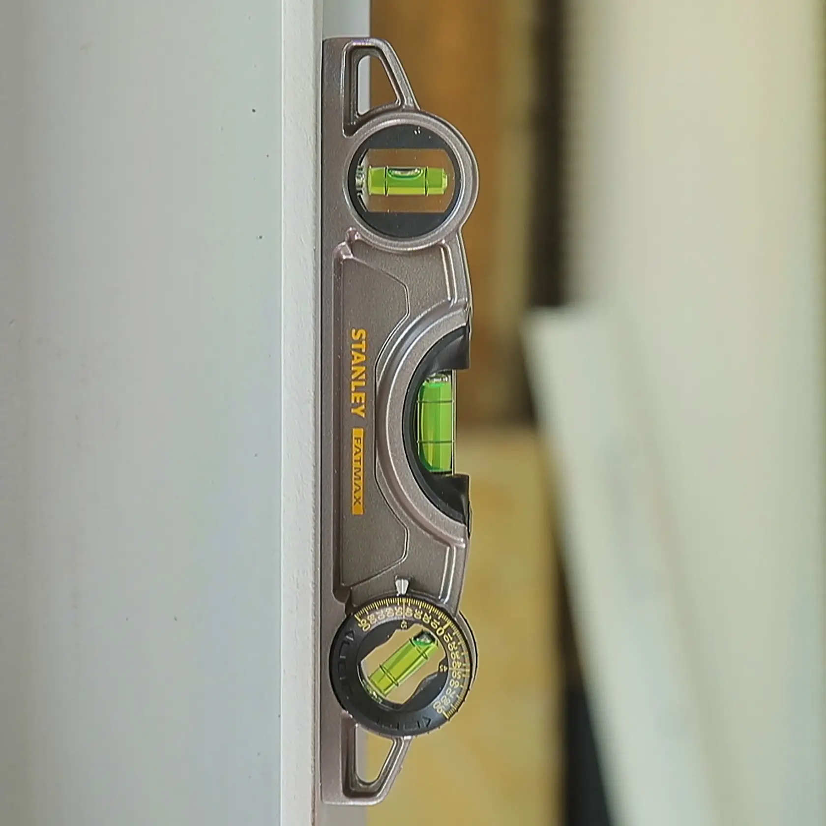 Stanley 0-43-609 photography of multi-angle spirit level tool attached vertically on a white surface.