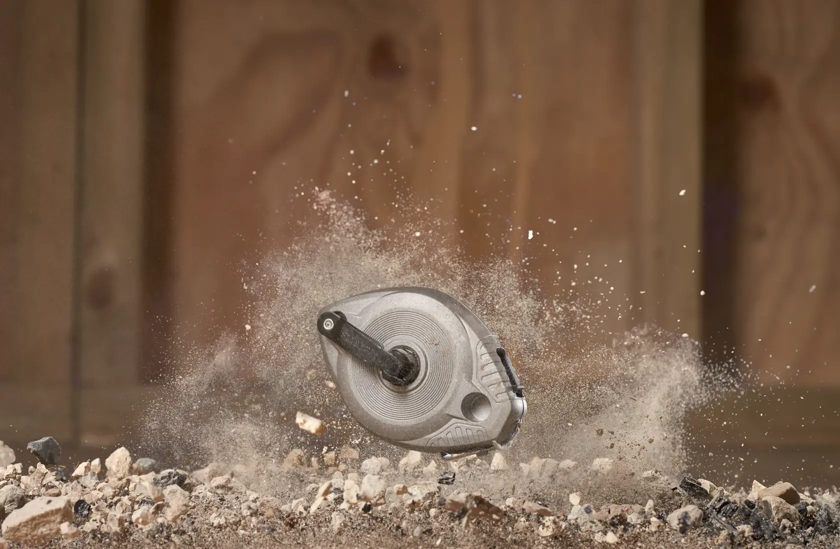 Foto der STANLEY 0-47-100 Schlagschnurrolle, gehalten in einer behandschuhten Hand auf Beton.
