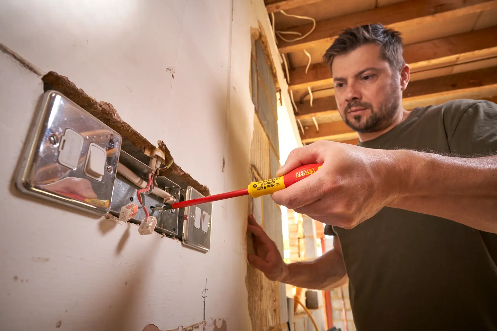 Photo of STANLEY 0-65-419 insulated screwdriver used on electrical outlet during installation.