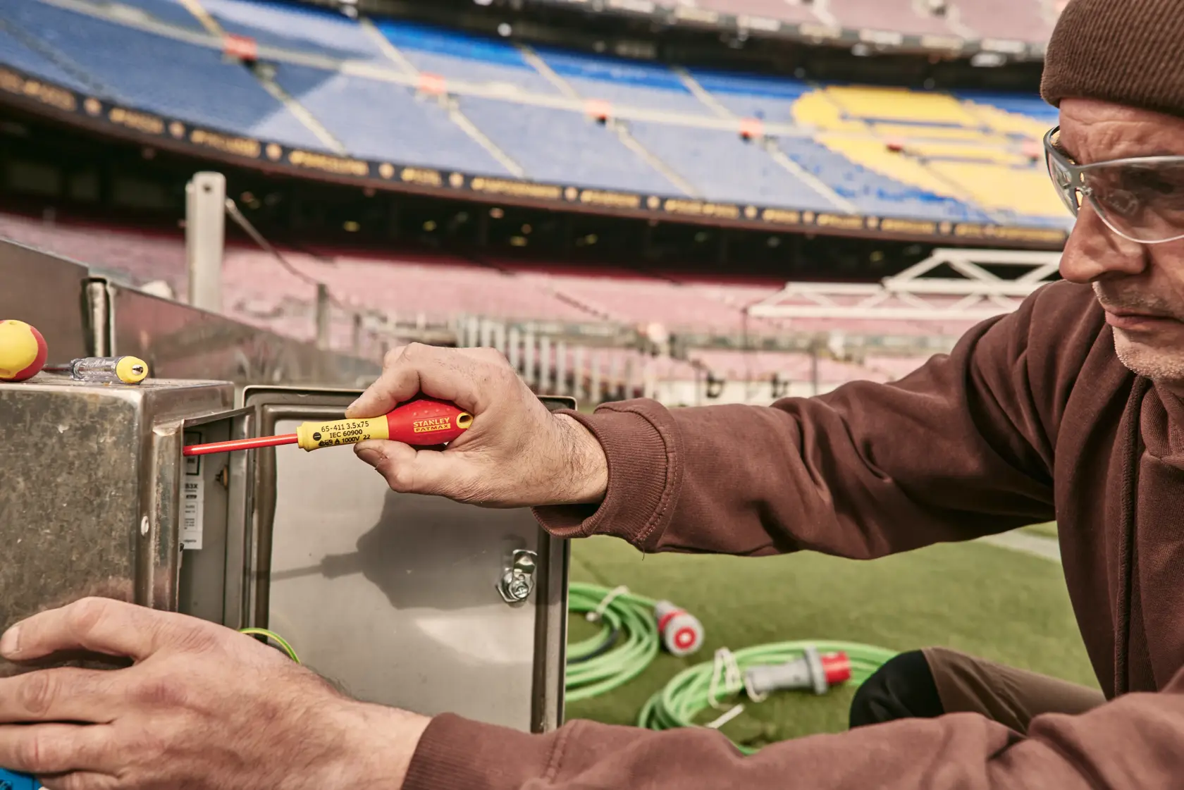 Photo of STANLEY 0-65-443 insulated screwdriver used on metal electrical box outdoors in a stadium.
