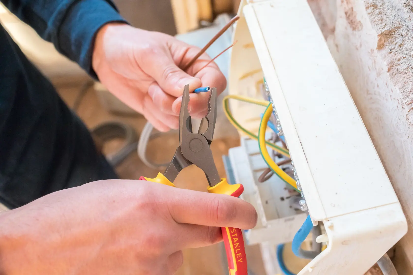 STANLEY 0-84-000 Zange wird verwendet, um ein Kabel in der Nähe eines Elektropanels abzuisolieren.