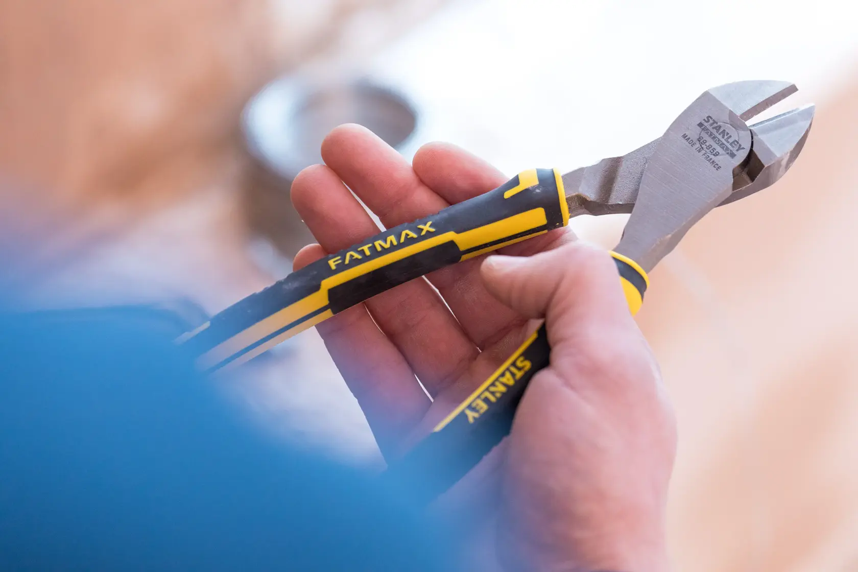 STANLEY 0-89-859 Diagonal-Schneidzange mit schwarzen und gelben FATMAX Griffen in der Hand gehalten.