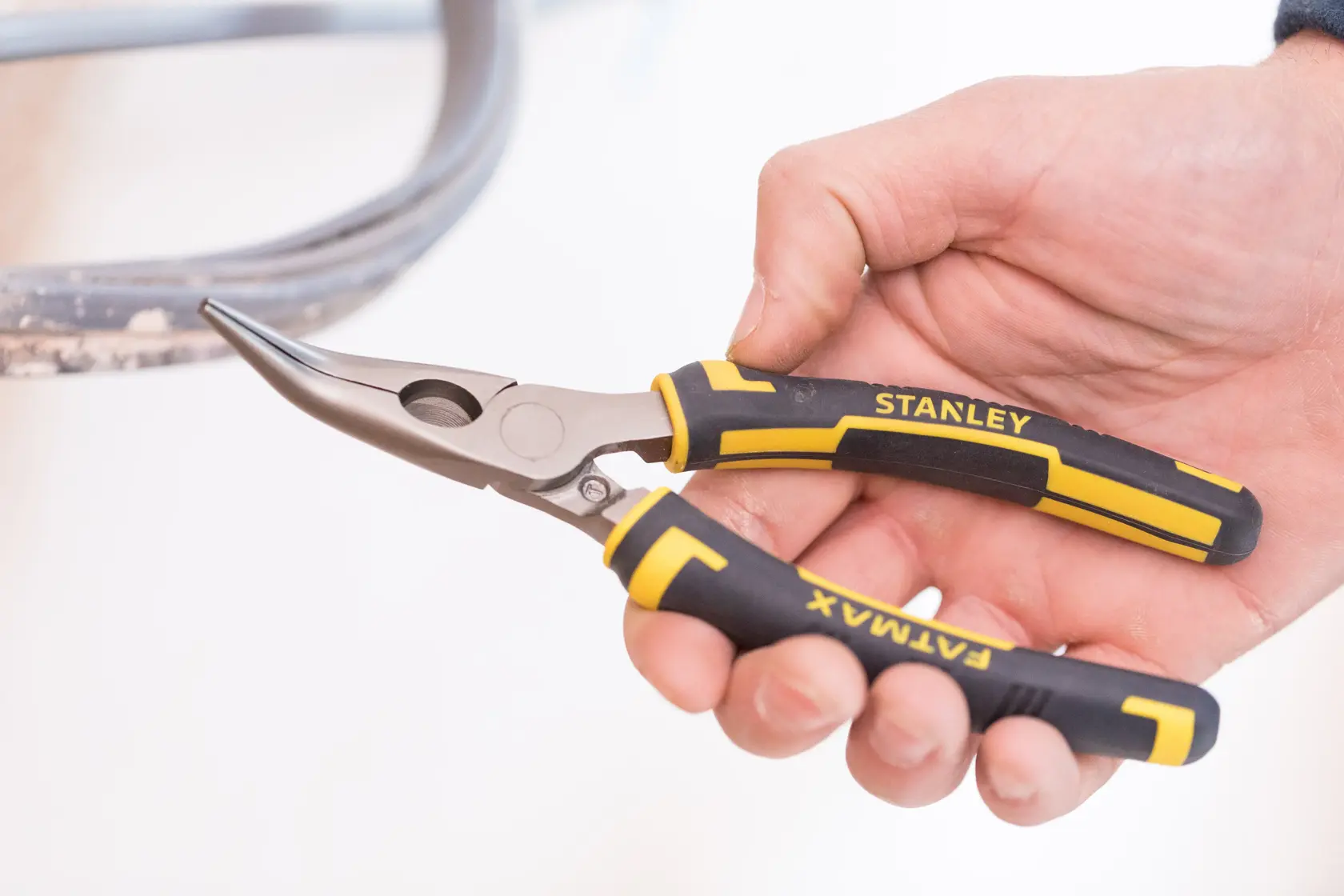 STANLEY 0-89-871 Spitzzange mit schwarz-gelben FATMAX Griffen, in der Hand gehalten, Seitenansicht.