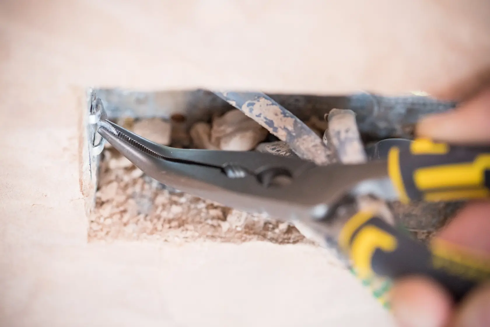 Stanley 0-89-872 pliers gripping wire in electrical box, close-up, photography of hand tool usage.
