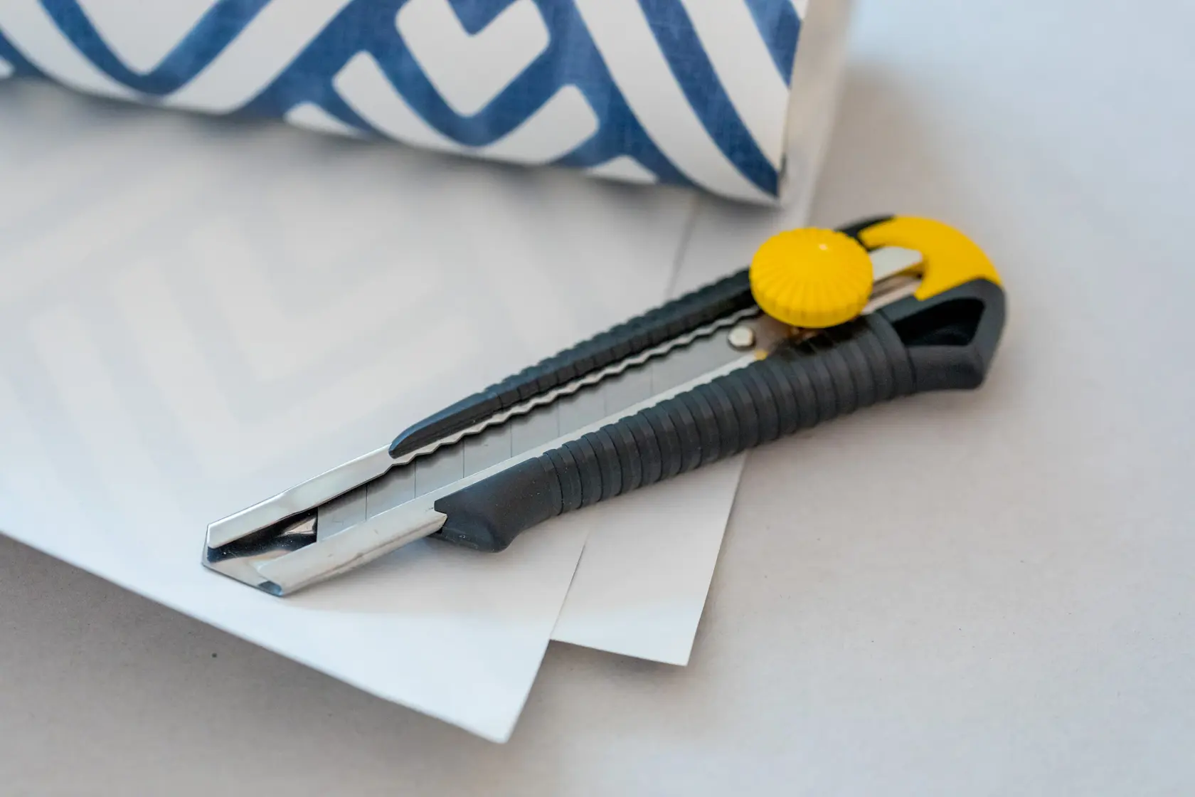 STANLEY 1-10-418 utility knife with black and yellow handle on paper, side view.