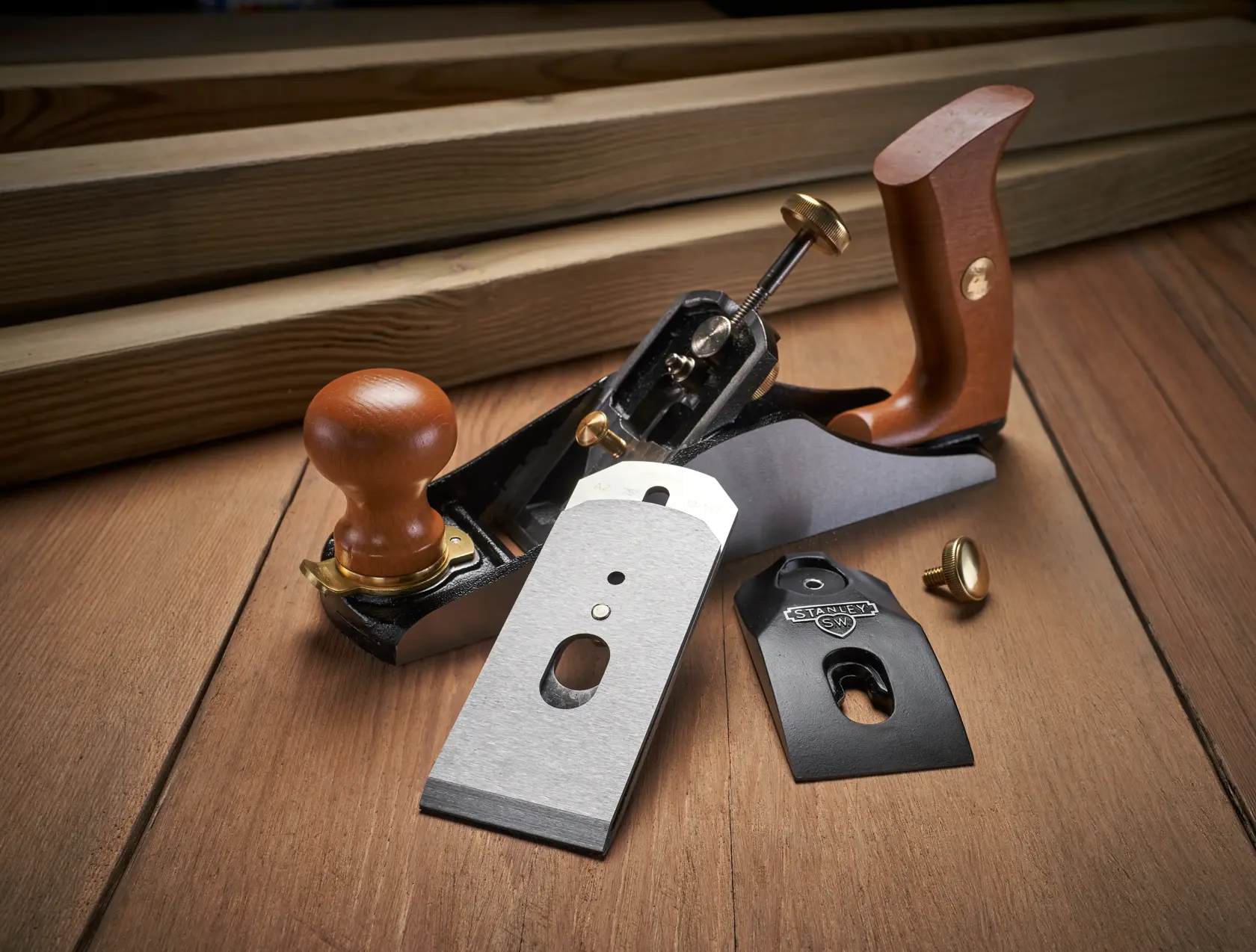 Foto von STANLEY 1-12-136 Hobel mit Holzgriffen und zerlegten Klingen auf Holzoberfläche.