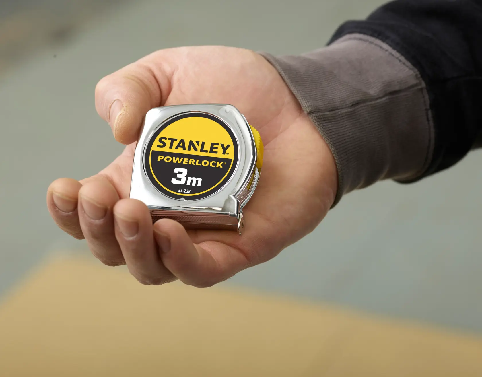 STANLEY 1-33-238 PowerLock Maßband, 3m, silbernes Gehäuse, in der Hand gehalten.