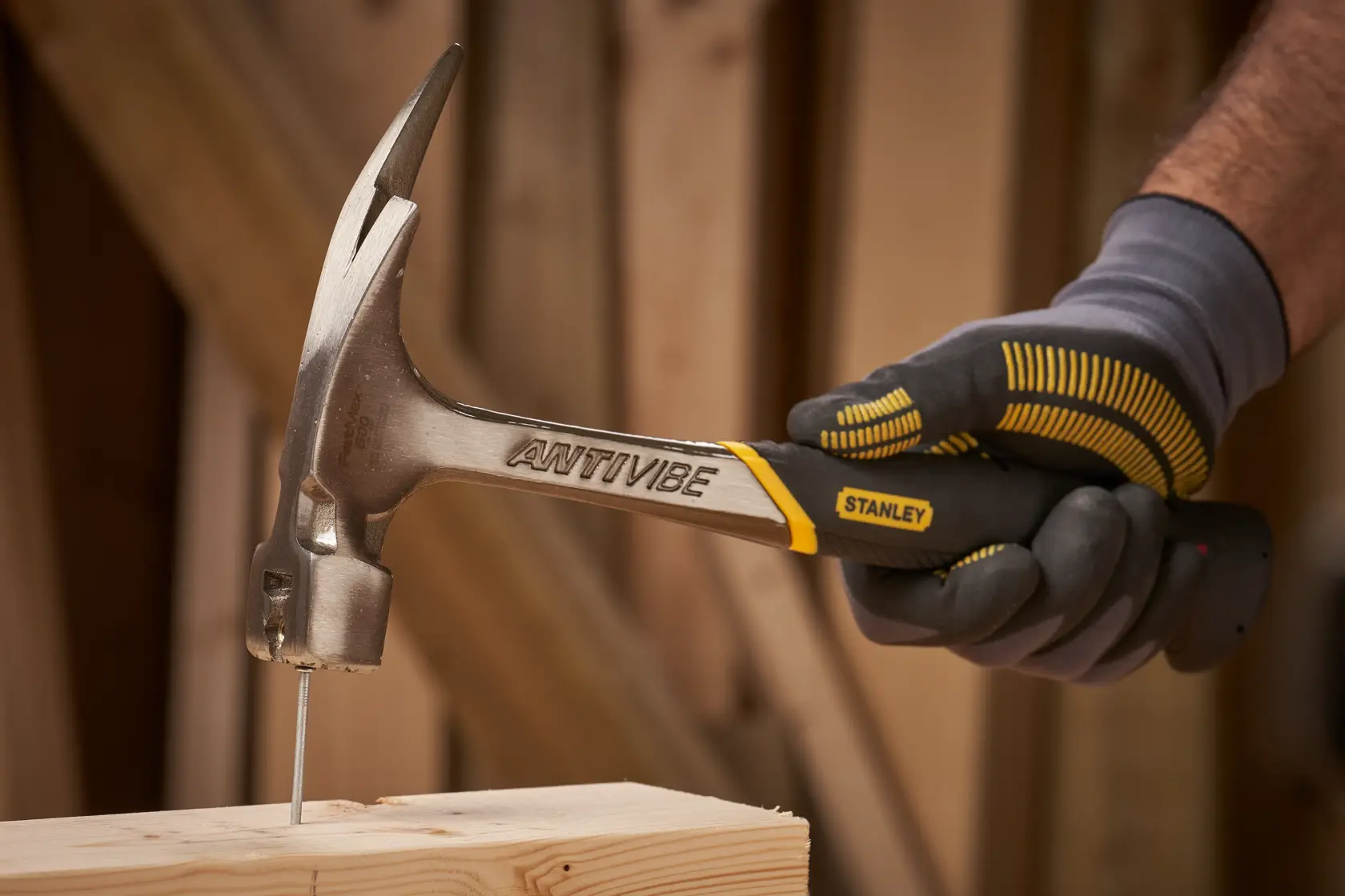Stanley 1-51-937 Klauenhammer im Einsatz, Nagel in Holz schlagend, Seitenansicht Foto.