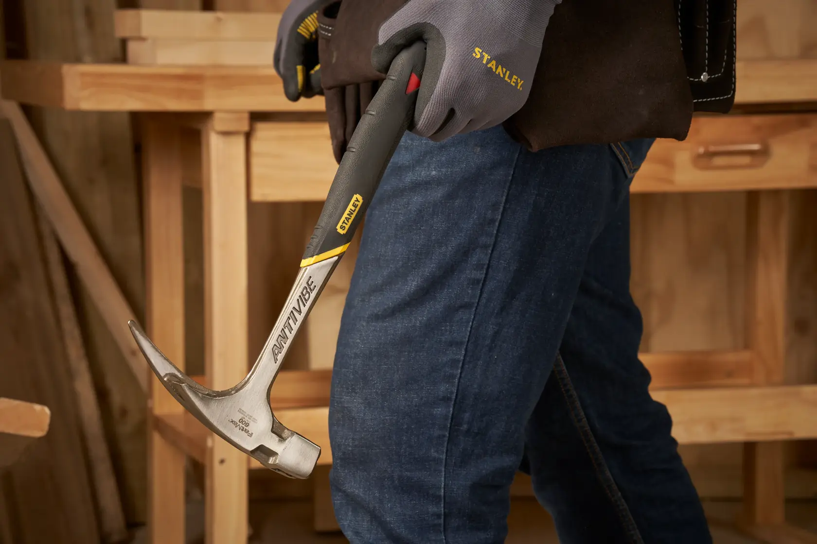 STANLEY 1-51-937 Hammer mit Anti-Vibe-Griff in einer behandschuhte Hand im Werkstattbereich.