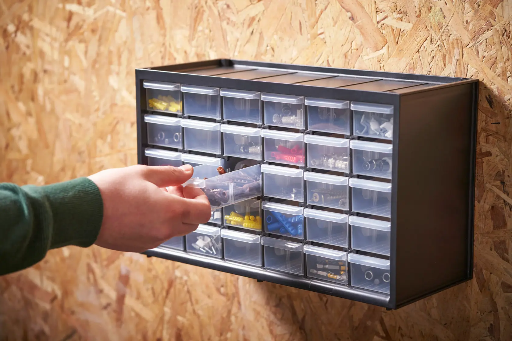 STANLEY 1-93-980 Organizer mit transparenten Schubladen an der Wand, Hand entnimmt Inhalt.