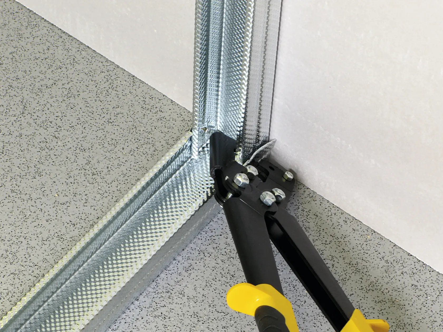 STANLEY 15-273 Metall-Schneidewerkzeug im Einsatz an einer Stahlprofil-Ecke, Nahaufnahme Fotografie.