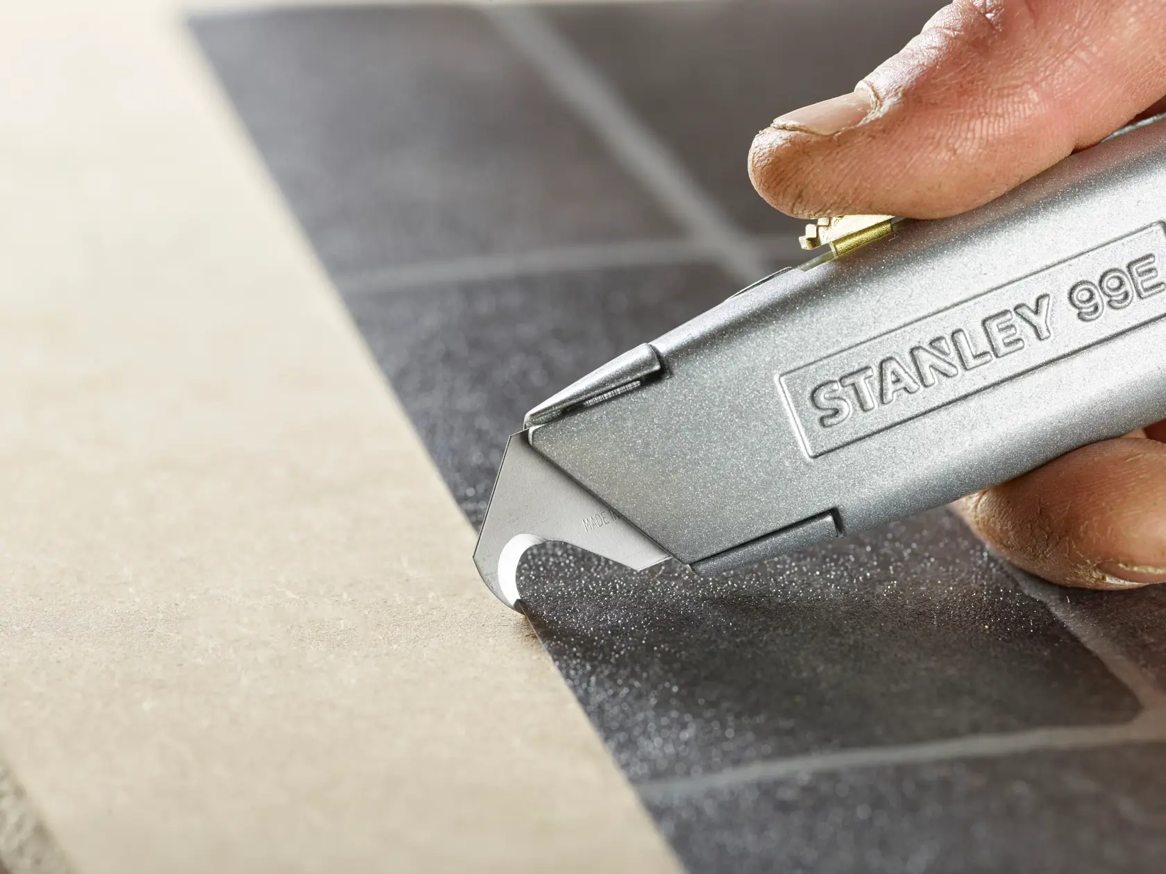 STANLEY 2-11-983 Universalmesser schneidet Fliese, Nahaufnahme Fotografie.