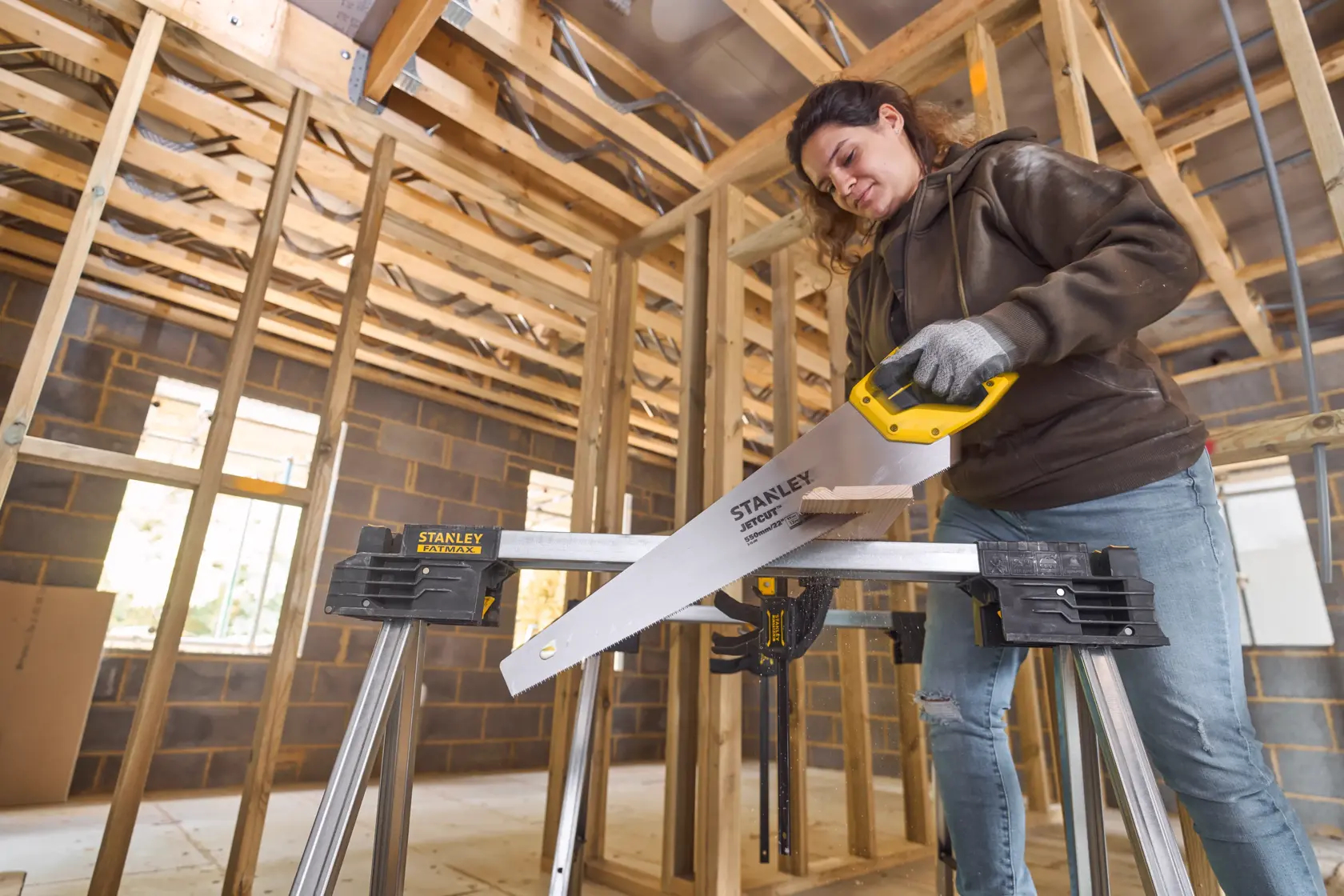 Foto der STANLEY 2-15-244 Handsäge auf Werkbank, Person mit Handschuhen markiert Holz.