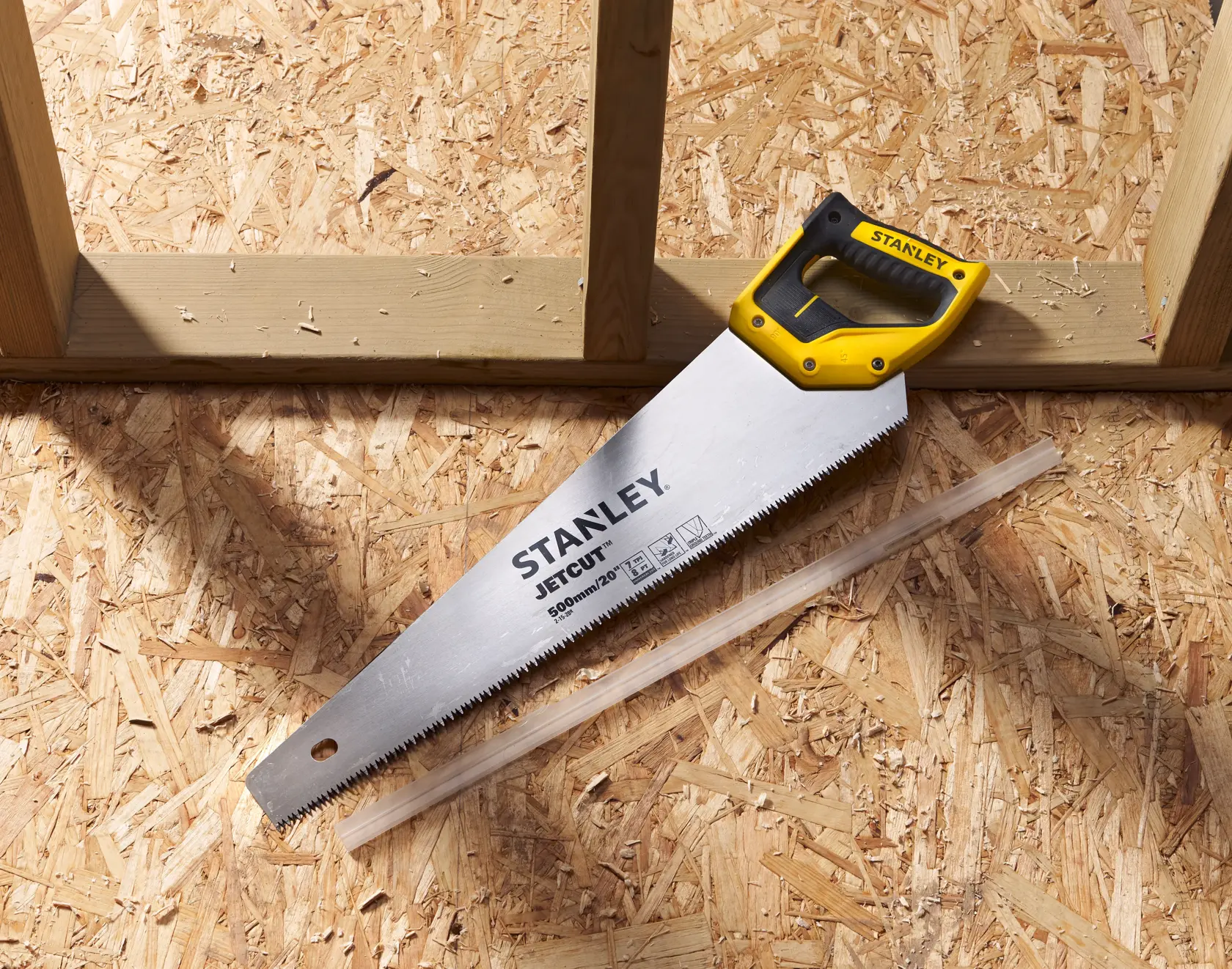 STANLEY 2-15-288 Handsäge mit gelb-schwarzem Griff auf Holzplatte, Draufsicht.