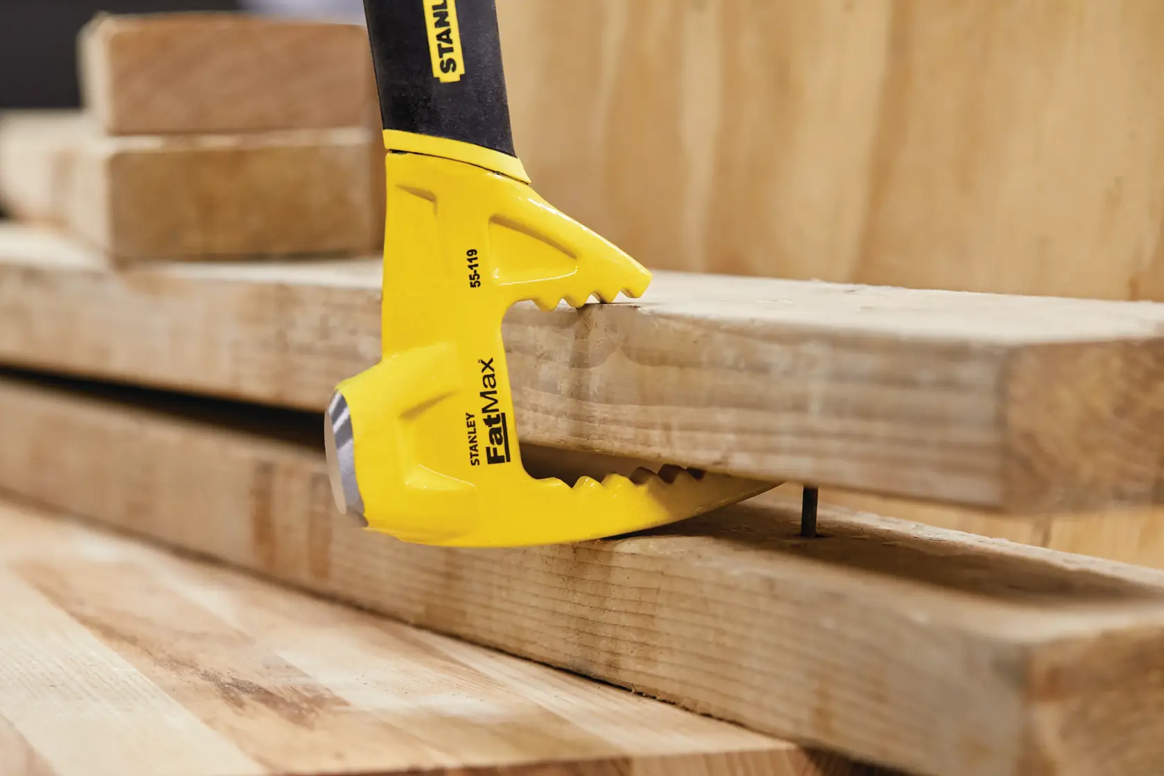 STANLEY 55-119 FatMax Abrisswerkzeug hebelt Holzlatten mit Kralle in Baustellenszene.