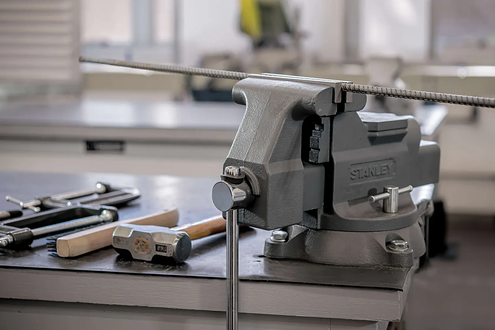 STANLEY Schraubstock 83-066, 1-83-066 auf Werkbank, mit Werkzeugen und Metallstab, Seitenwinkel-Fotografie.