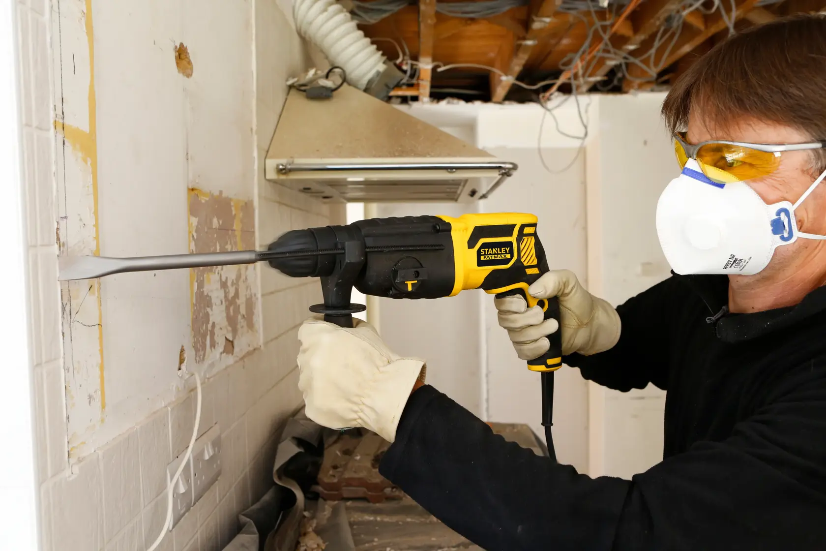 STANLEY FME500K FATMAX SDS-Plus Hammer being used to chisel wall tiles in a renovation setting.