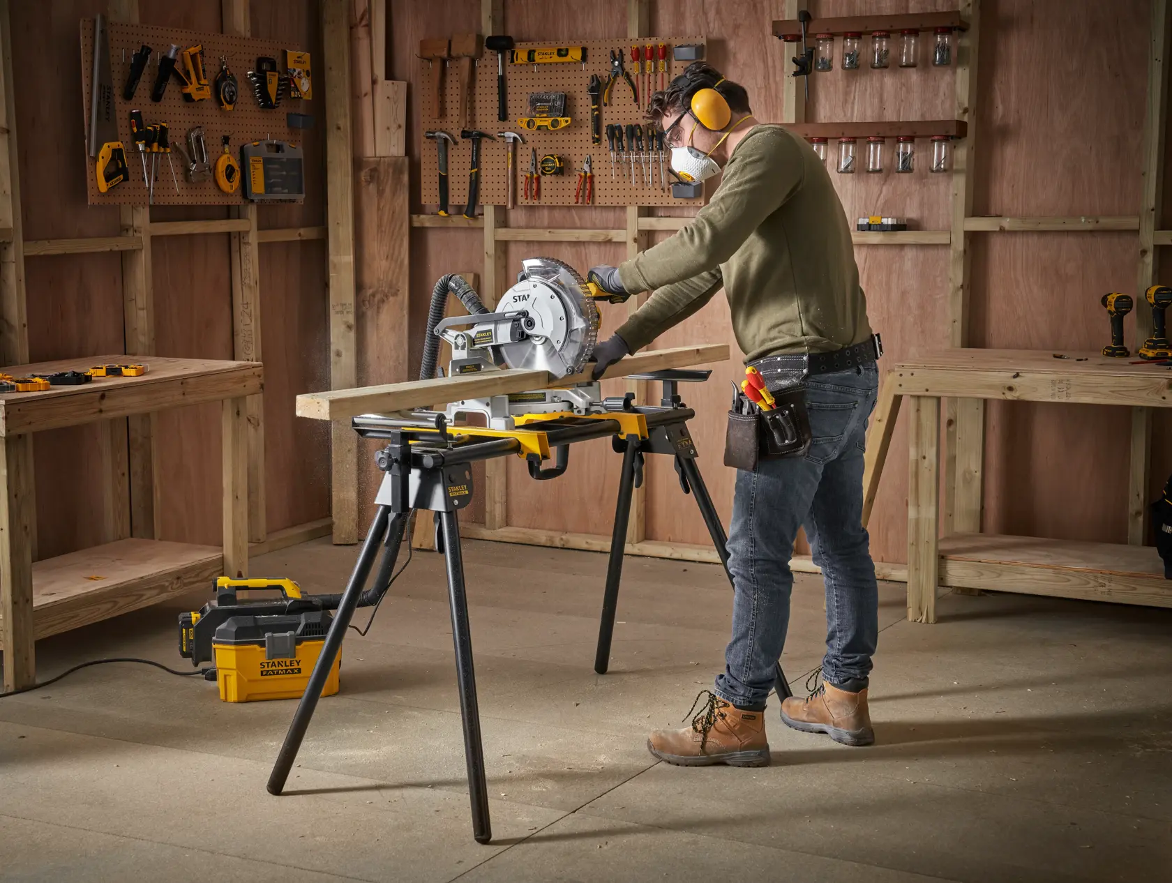 STANLEY FME790-XJ Kappsäge im Einsatz auf Werkbank, Mann schneidet Holz in Werkstatt.
