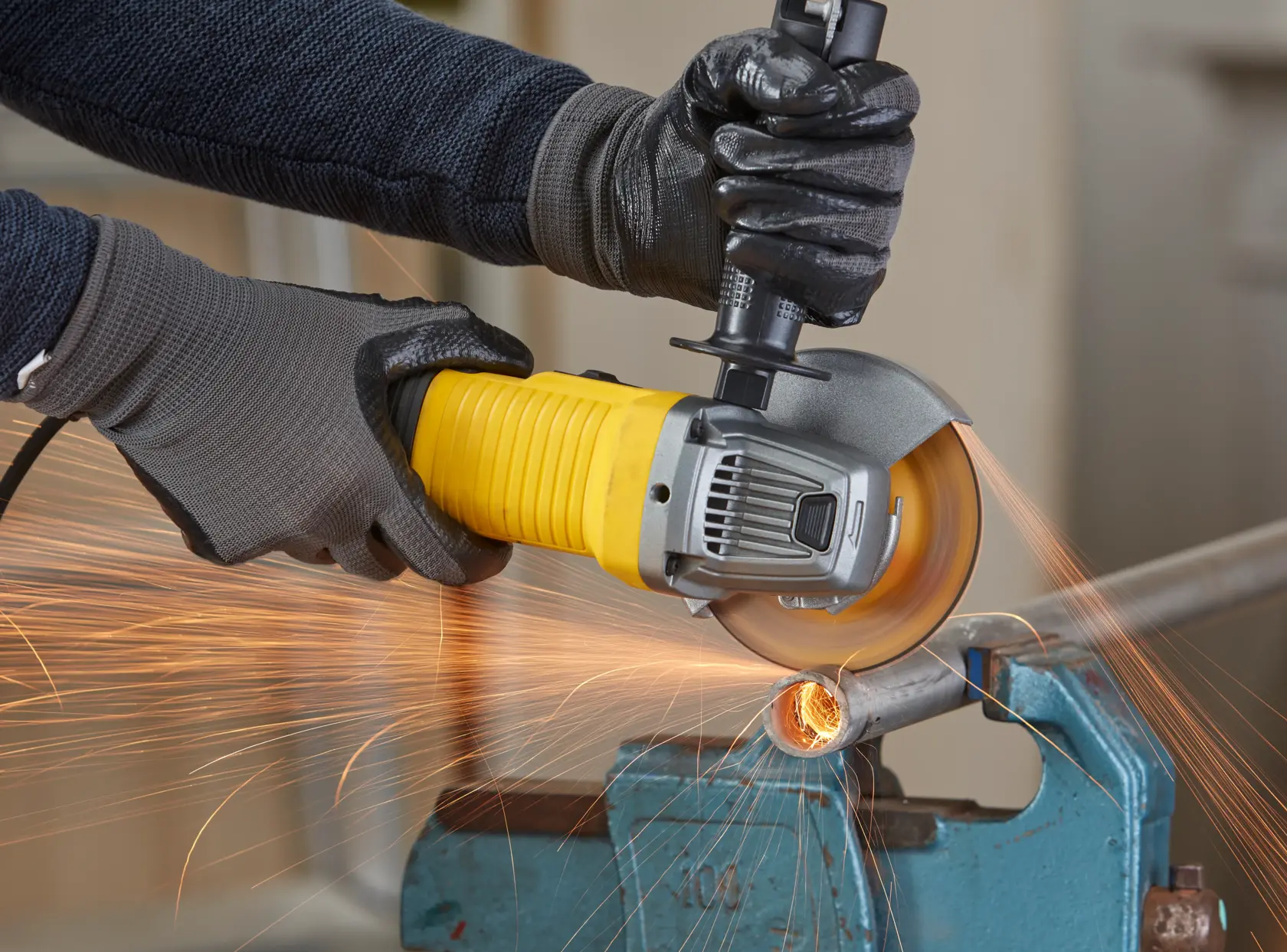 STANLEY FMEG220K Winkelschleifer im Einsatz, Metallrohr wird geschnitten, Funkenflug, Nahaufnahme.