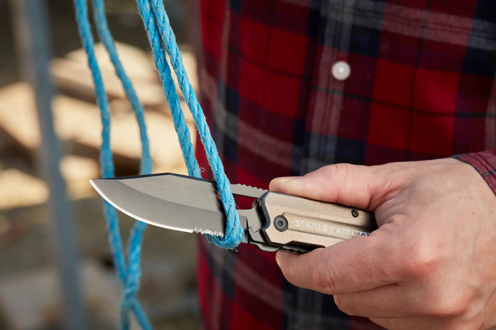 STANLEY FMHT0-10311 Klappmesser schneidet blaues Seil, Nahaufnahme im Freien.