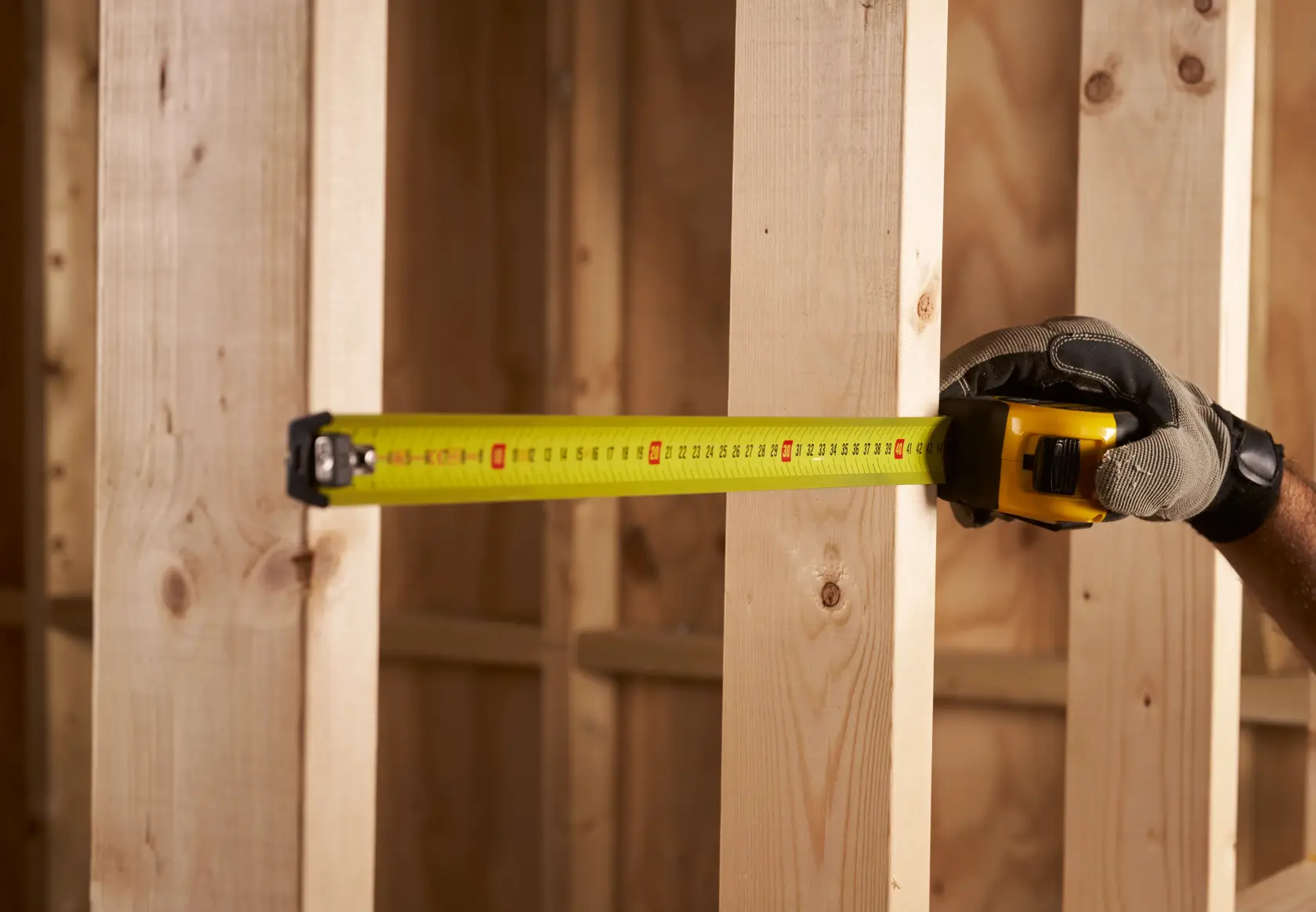 STANLEY FMHT0-33868 Bandmaß misst Holzständer, Nahaufnahme, Bausituation.