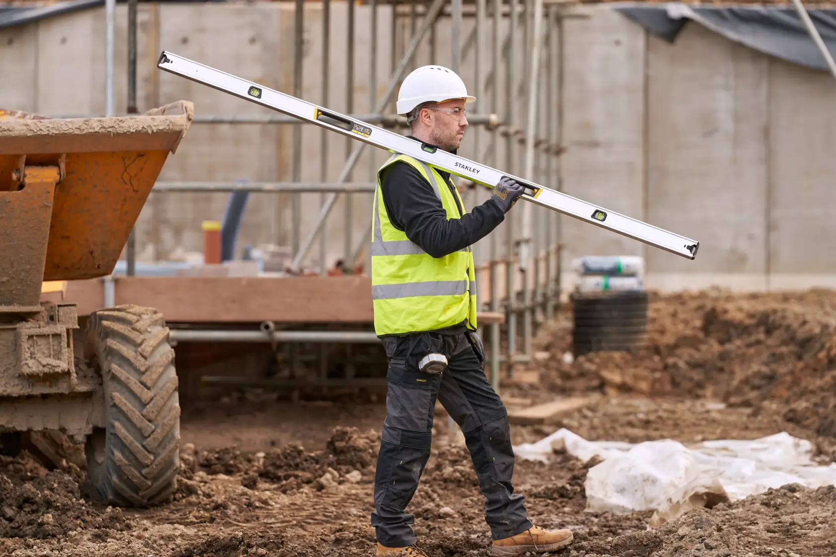 STANLEY FMHT43680-1 Wasserwaage, getragen von Bauarbeiter mit Sicherheitsausrüstung auf Baustelle.