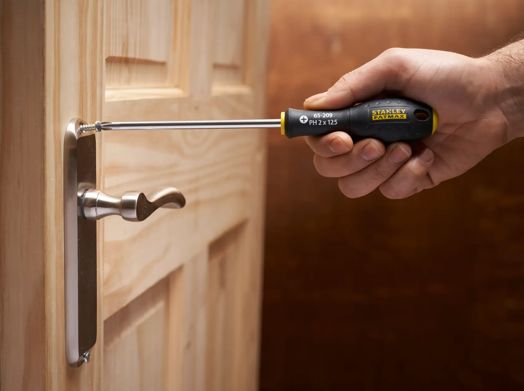 Photo of STANLEY FMHT65426-0 screwdriver being used to install a screw in a door handle.