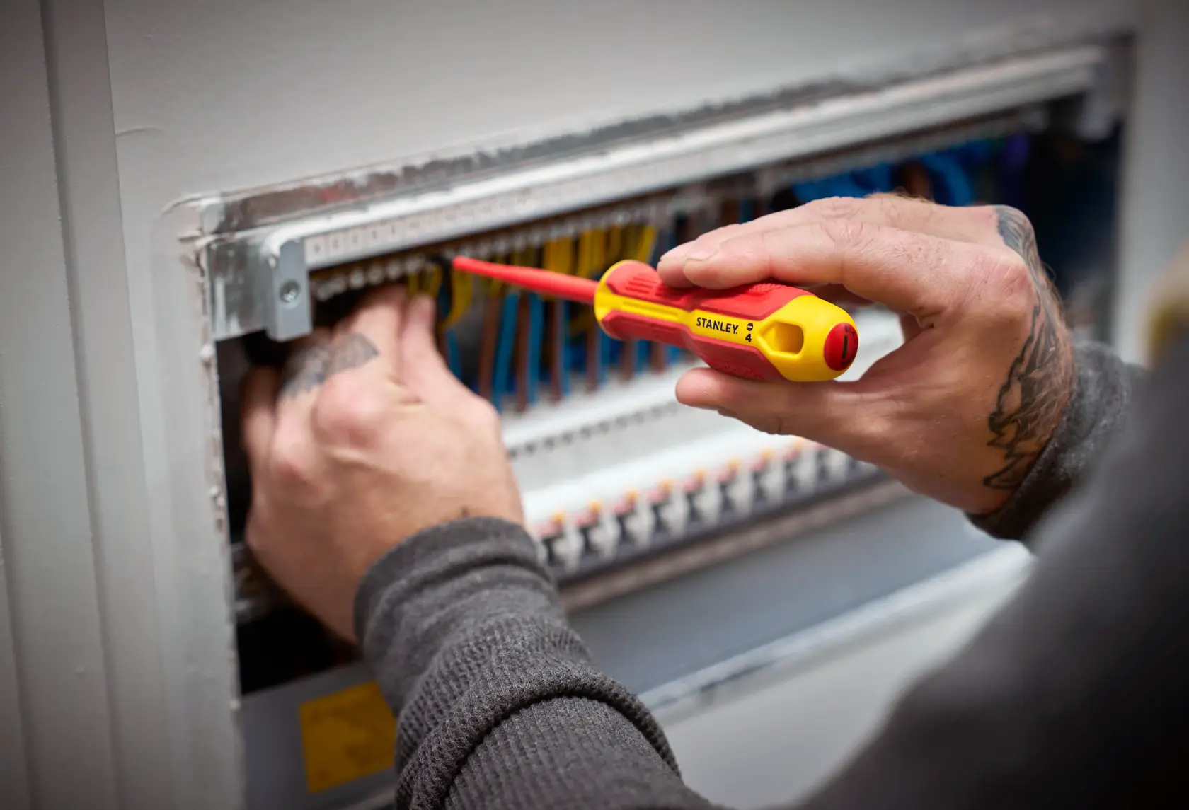 Person nutzt einen STANLEY isolierten Schraubendreher am Elektro-Panel mit mehreren Kabeln.