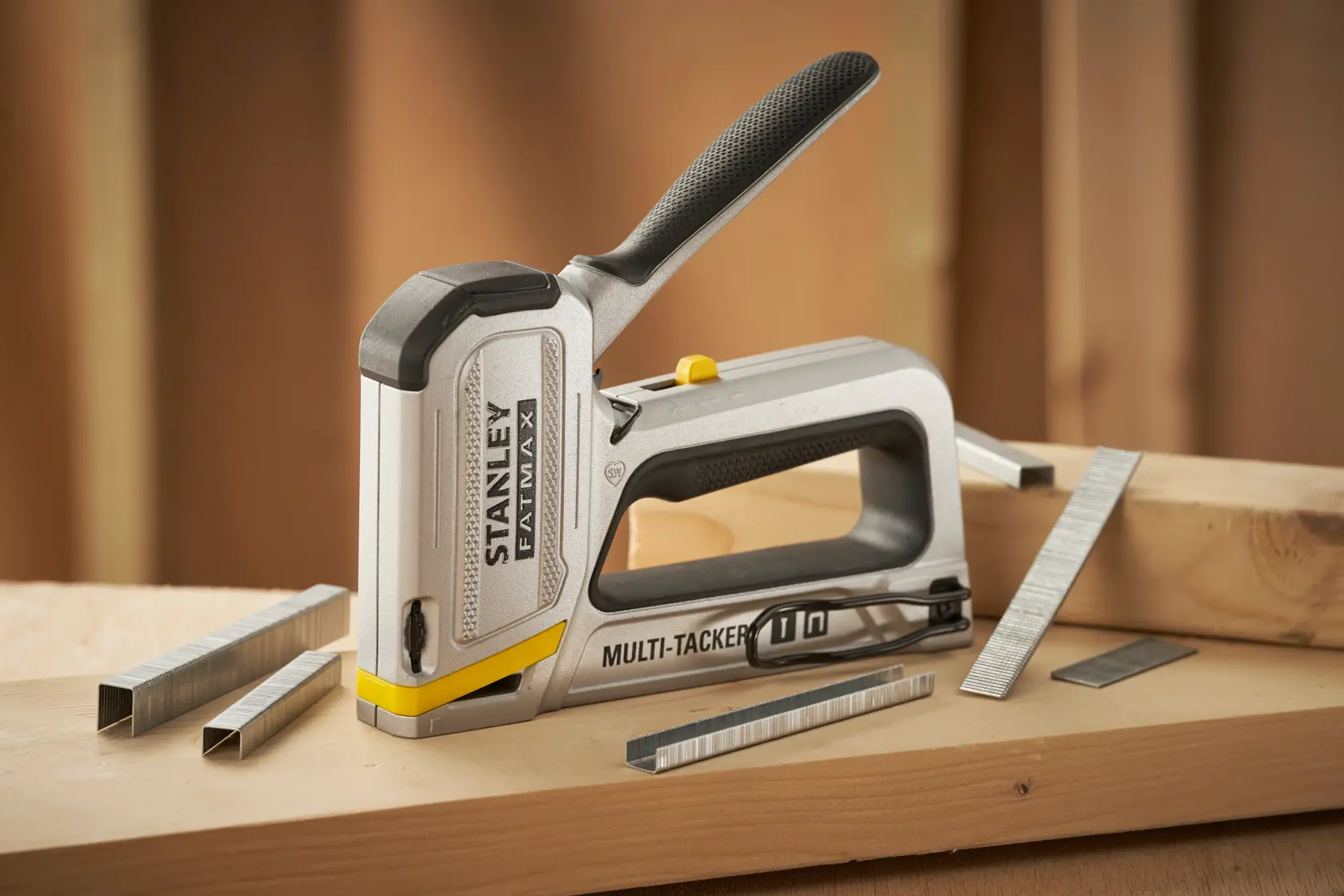 Stanley FMHT70250-0 Tacker mit Klammern auf Holzoberfläche, FATMAX Multi-Tacker ergonomischer Griff.
