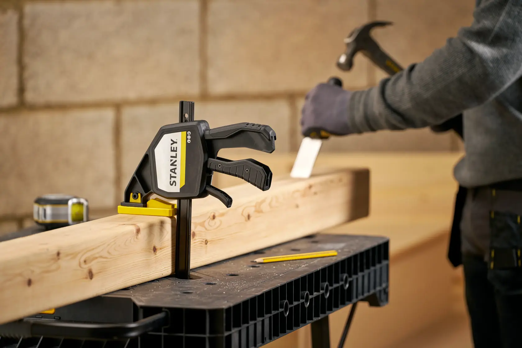 STANLEY FMHT83278-0 Zwinge sichert Holz auf Werkbank, Nahaufnahme im Handwerksbetrieb.