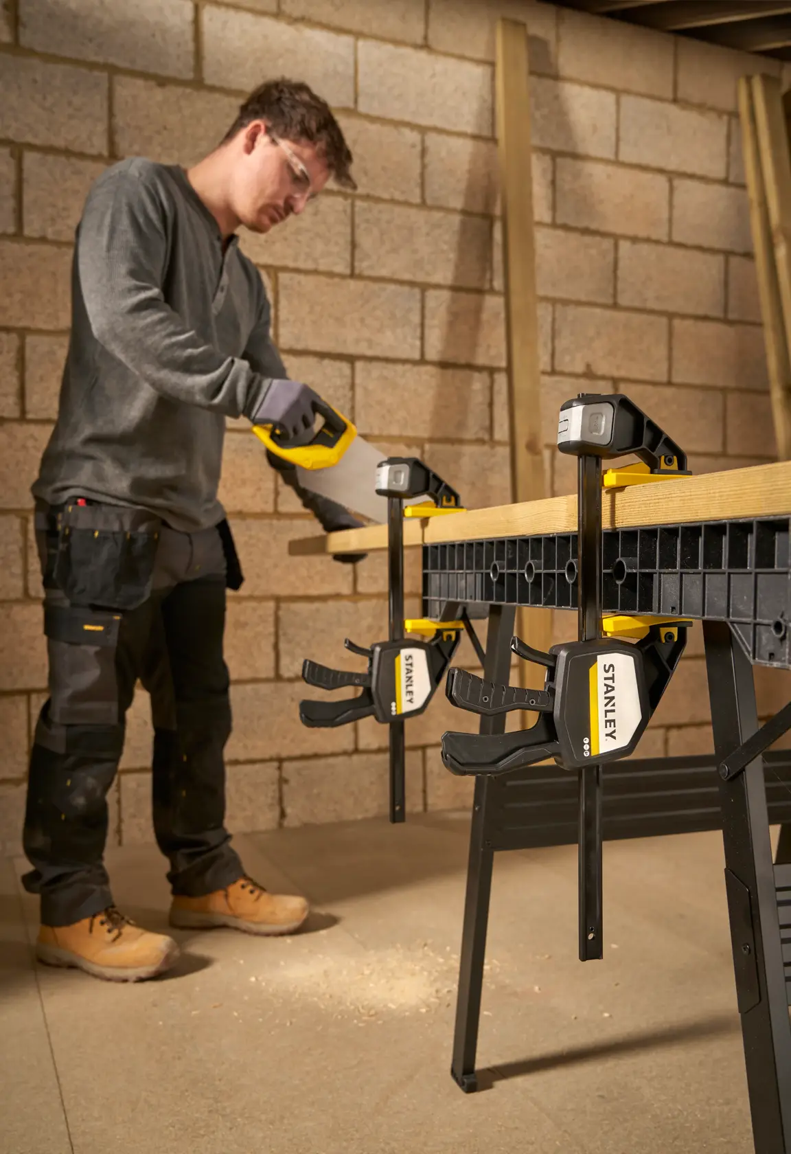 Foto von STANLEY FMHT83279-0 Schraubzwingen, die Holz auf einer Werkbank in einer Werkstatt sichern.