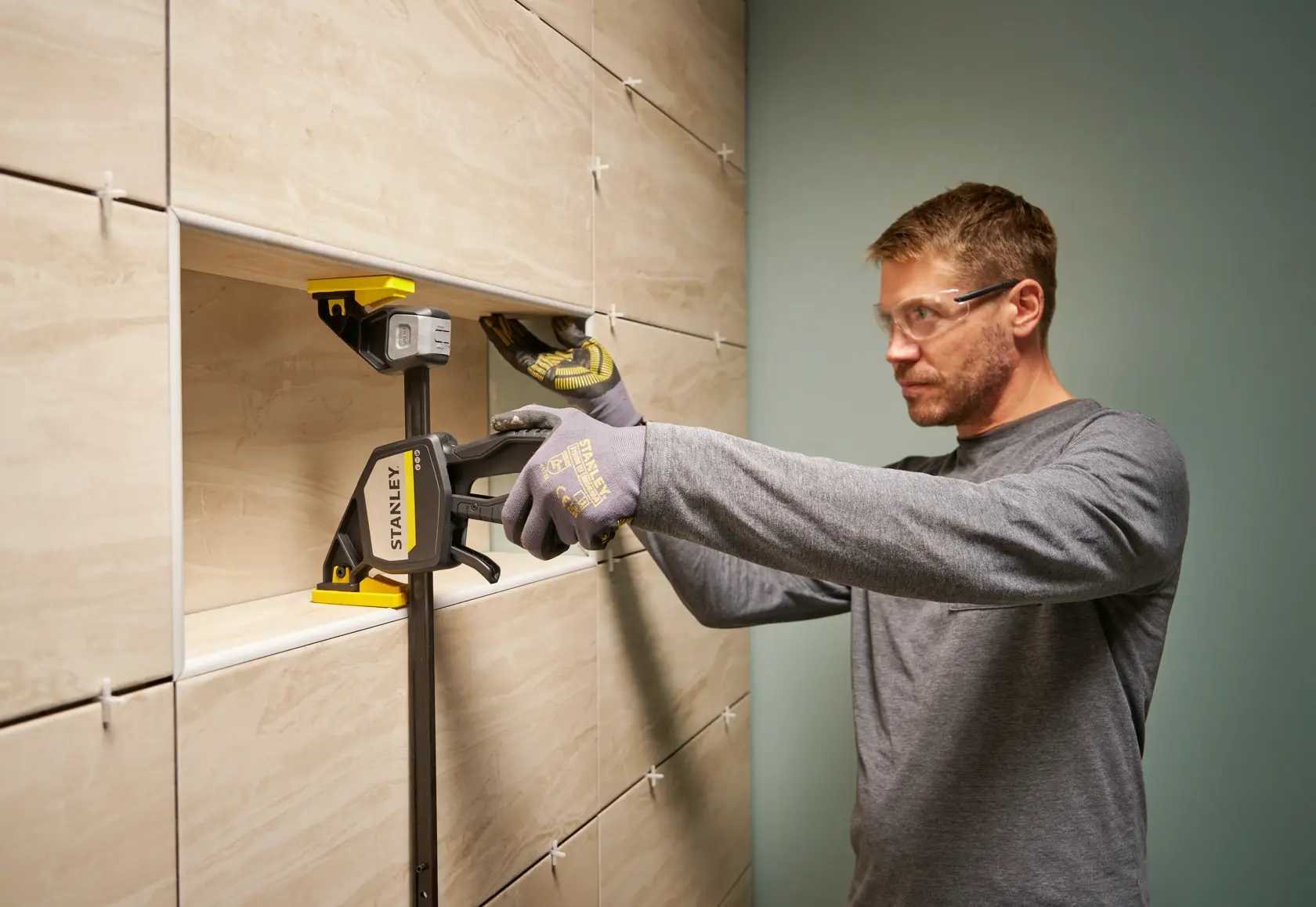 Foto der STANLEY FMHT83279-0 Zwinge, die Fliesen bei der Wandmontage fixiert.