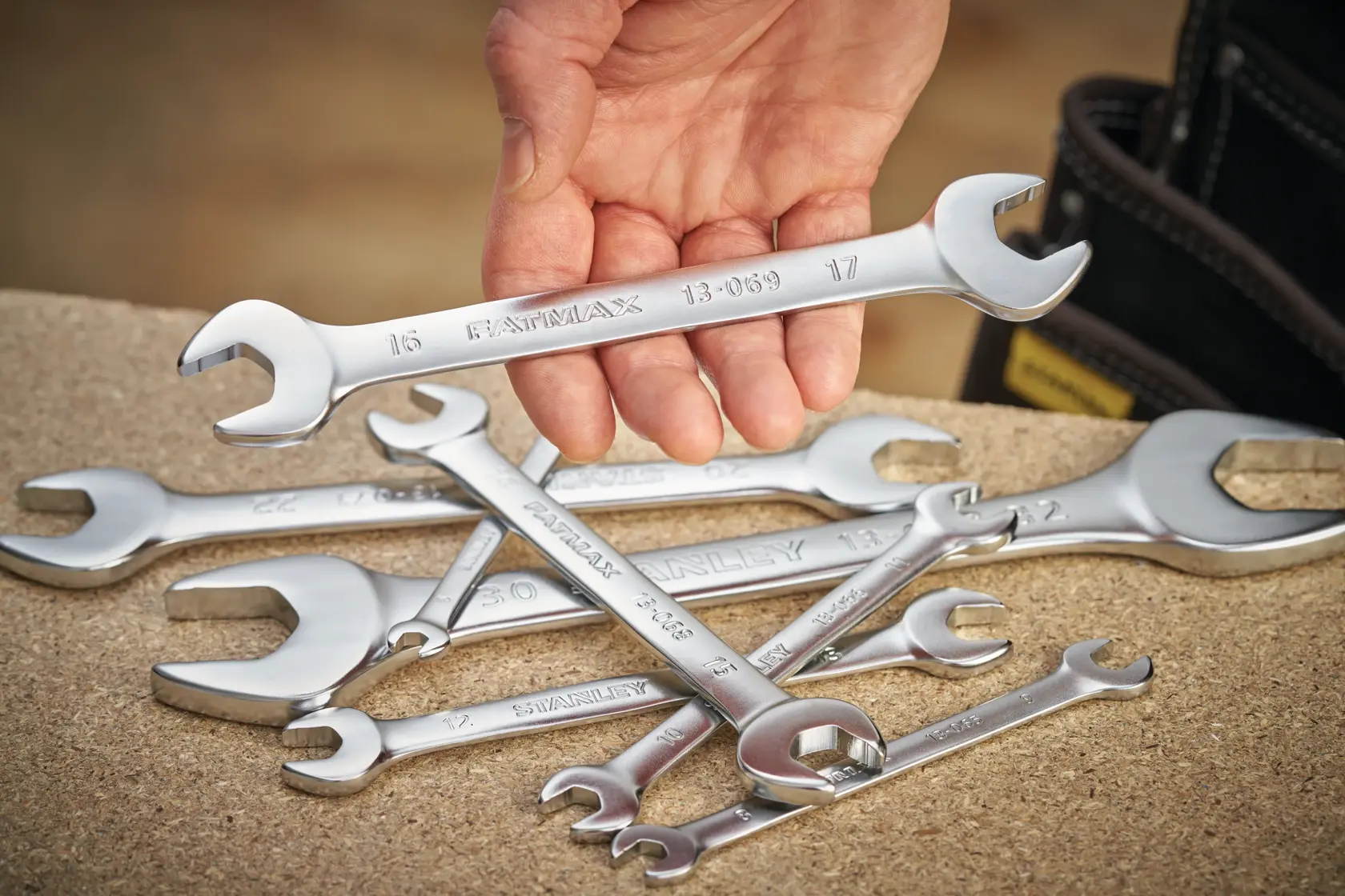 STANLEY FMMT13066-0 combination wrenches set displayed on a workbench, hand holding one wrench.