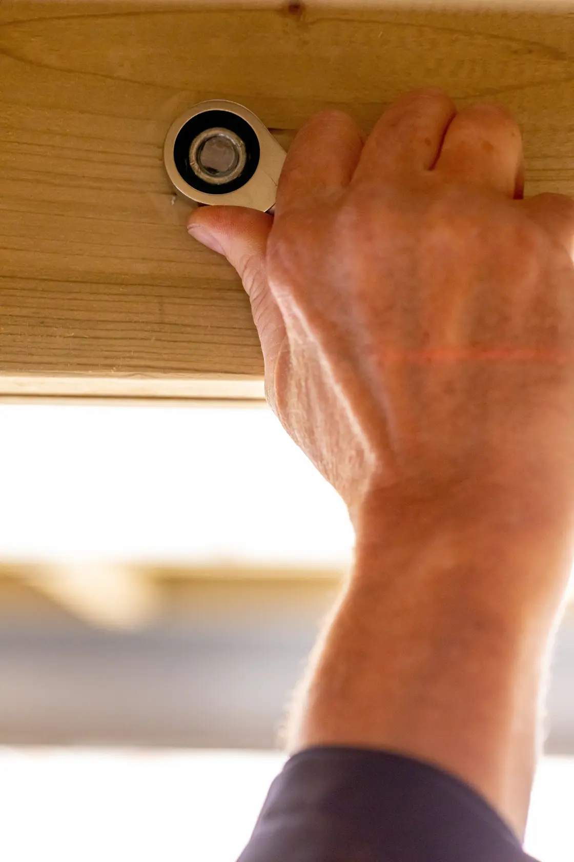 STANLEY FMMT13098-0 ratchet being used on a bolt in wood, close-up, indoor setting.
