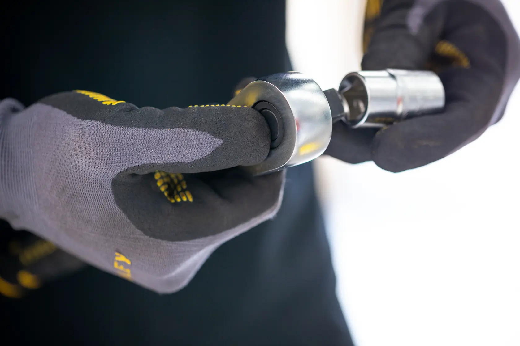 Stanley FMMT17220-0 socket tool held by gloved hands, close-up view, photography product category.