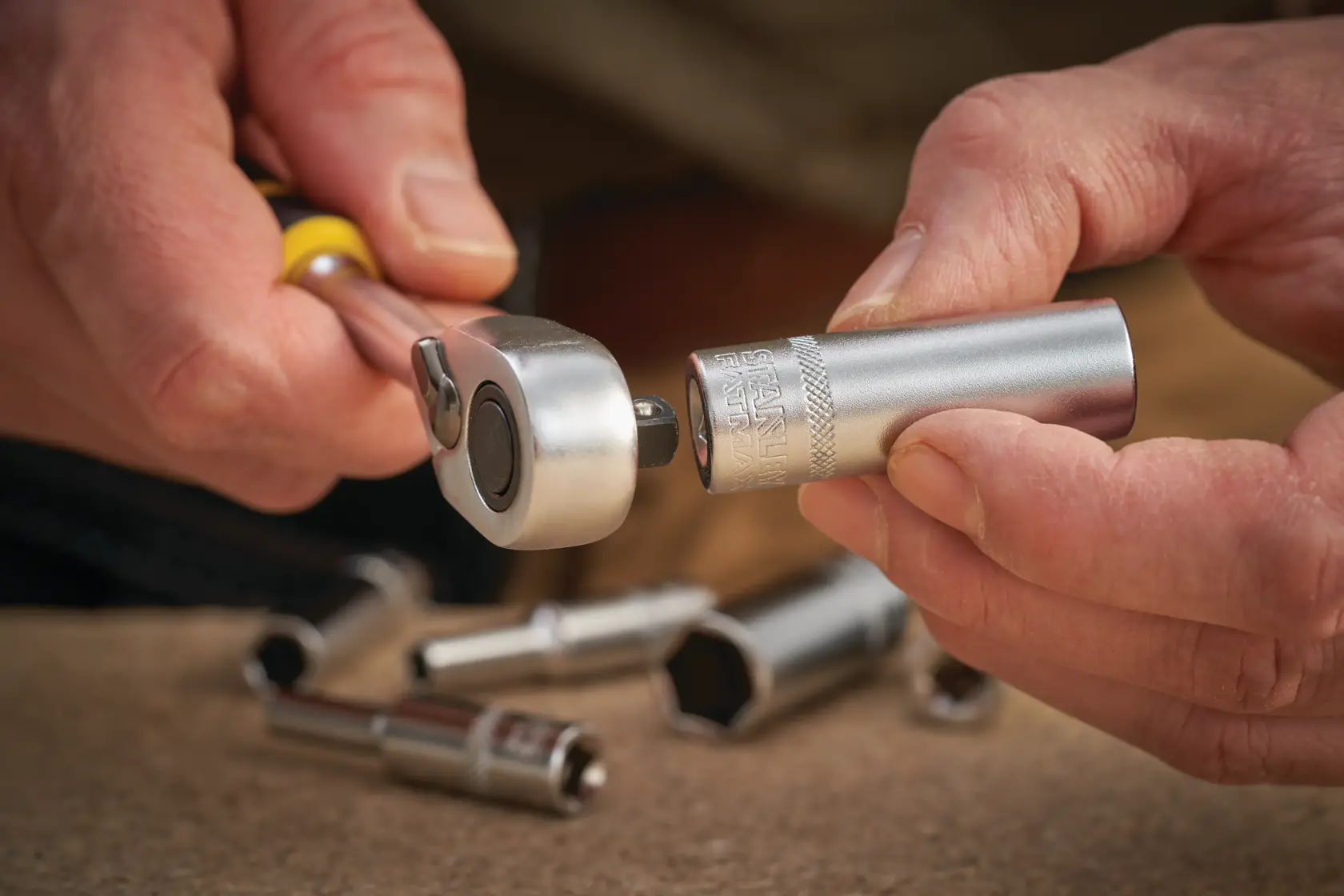 STANLEY FMMT17339-0 socket being attached to ratchet wrench, silver tools in foreground, close-up photography.