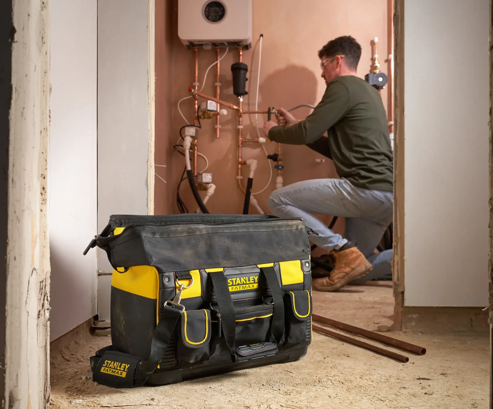STANLEY FMST1-71180 Werkzeugtasche in Schwarz und Gelb mit Außentaschen auf Baustellenboden.