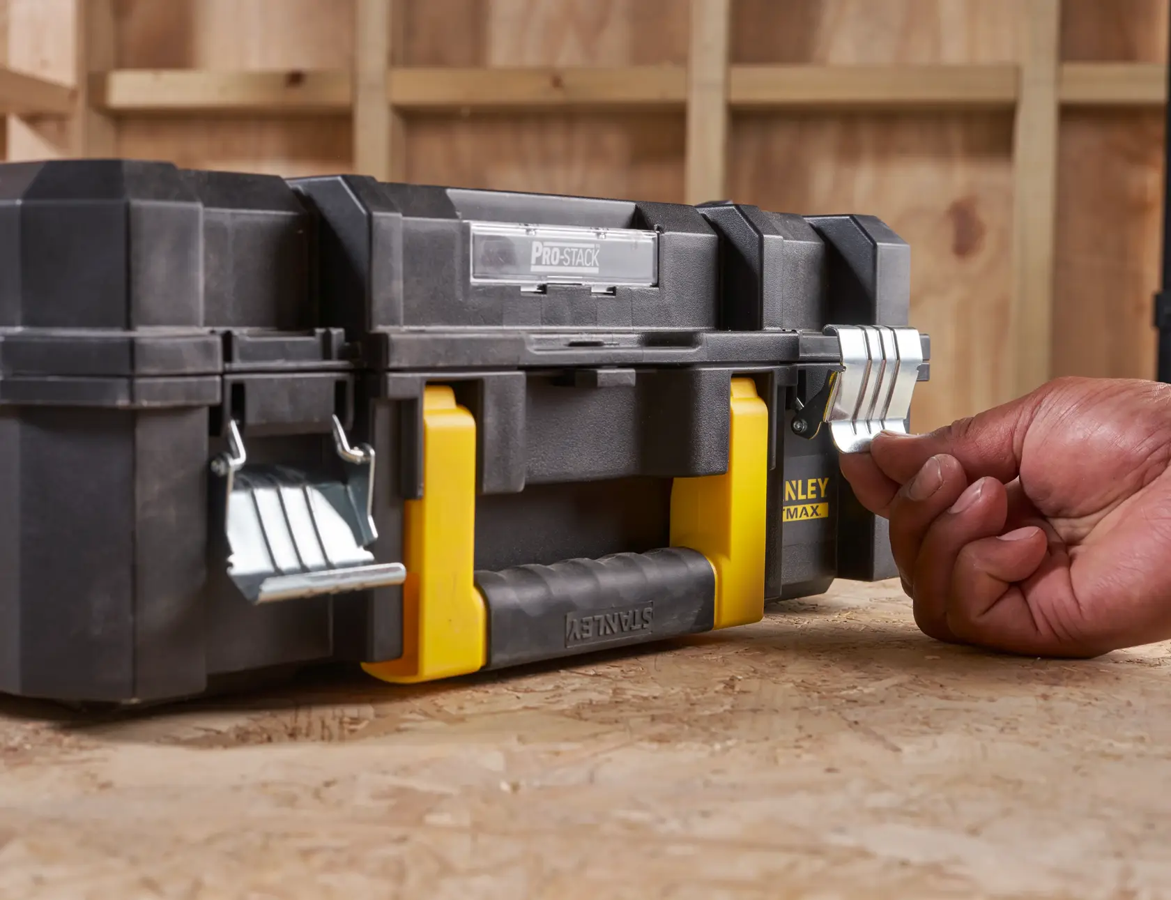 STANLEY FMST1-71966 toolbox with metal latches and yellow handle, front angle, hand unlocking latch.