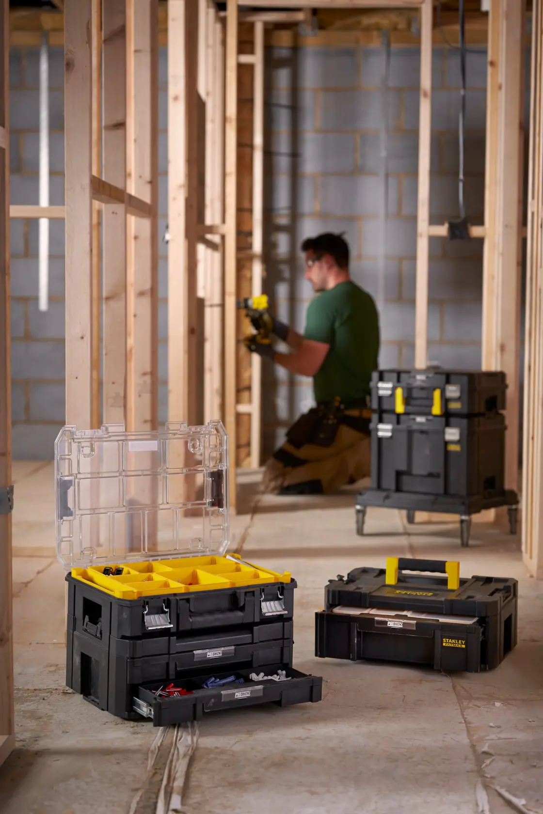 STANLEY FMST82967-1 modular toolboxes with yellow accents and clear lid, shown open on a construction site.