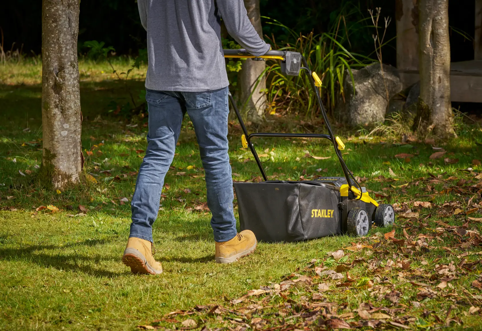 STANLEY SCOEP3801M2 Rasenmäher in Schwarz-Gelb im Einsatz auf Gras, Rückansicht.