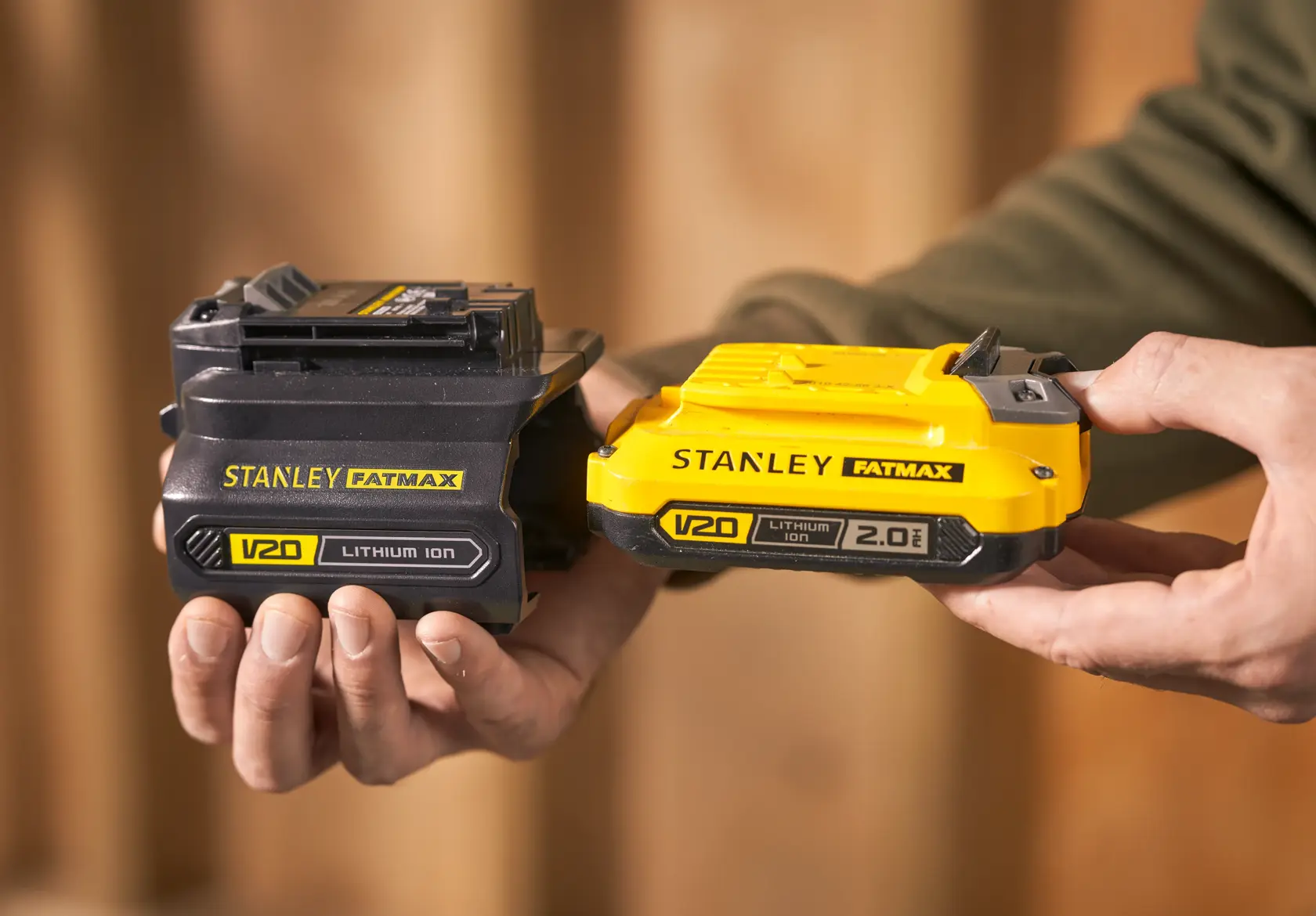 Photo of STANLEY SFMCB121D1 V20 lithium ion batteries, one black and one yellow, held in hand.