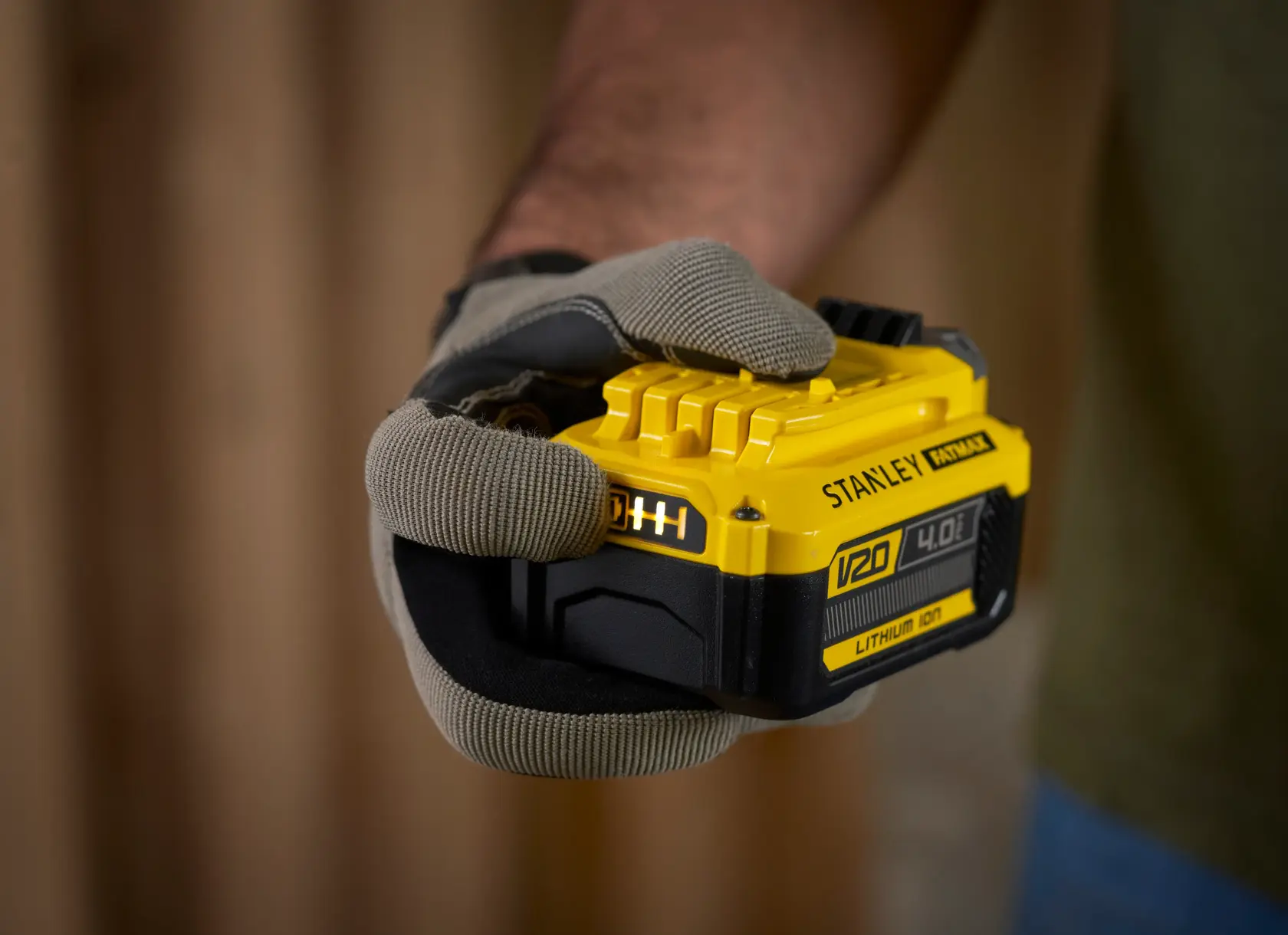 Foto des STANLEY SFMCB14M1 V20 4,0Ah Lithium-Ionen-Akkus in einer behandschuhten Hand.