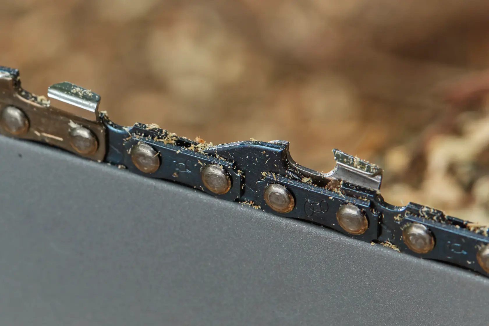 STANLEY SFMCCS630M1 chainsaw blade close-up showing metal teeth and sawdust.
