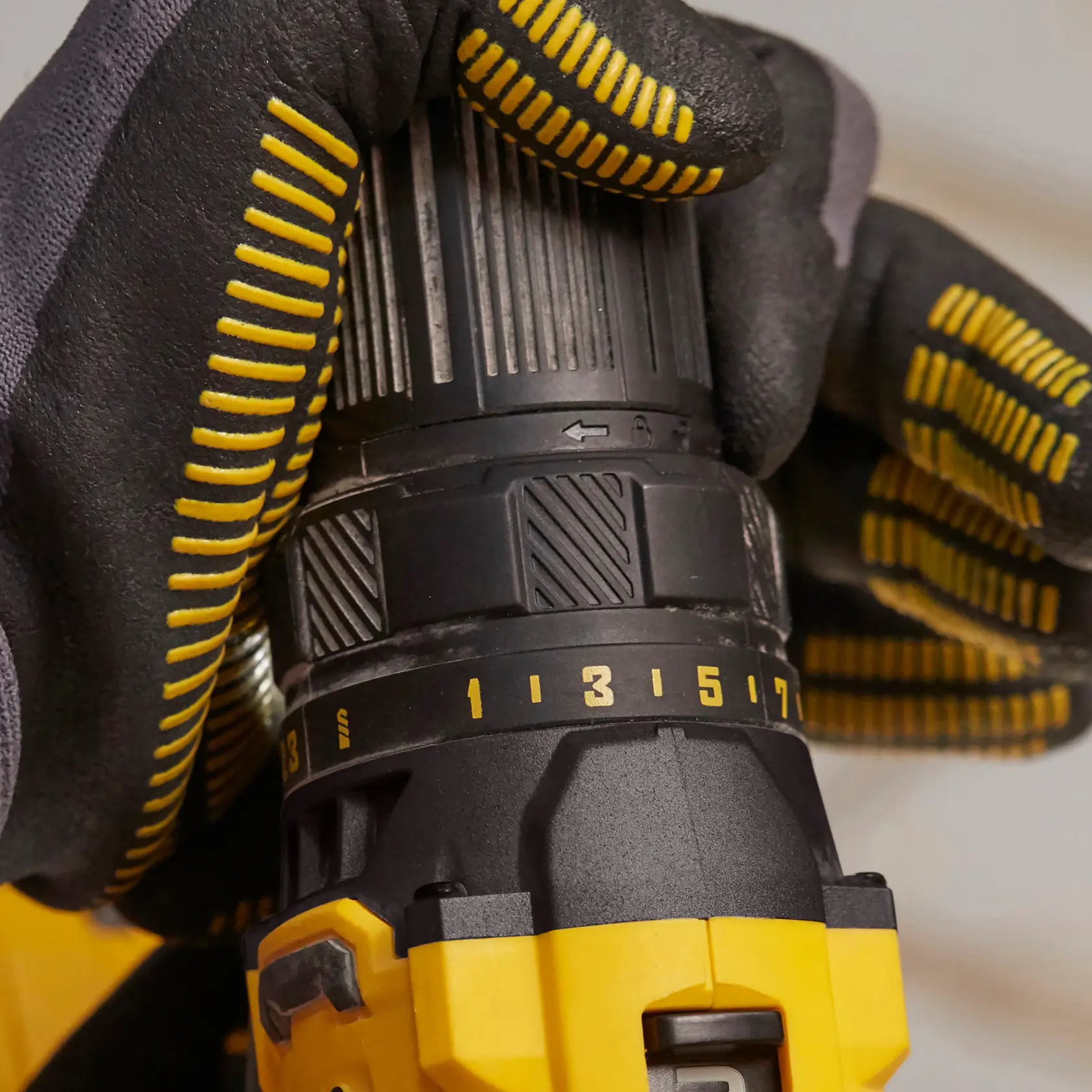 STANLEY SFMCD700C2K Bohrmaschine im Einsatz, Seitenansicht, schwarz-gelber Handschuh stellt Drehmoment ein.