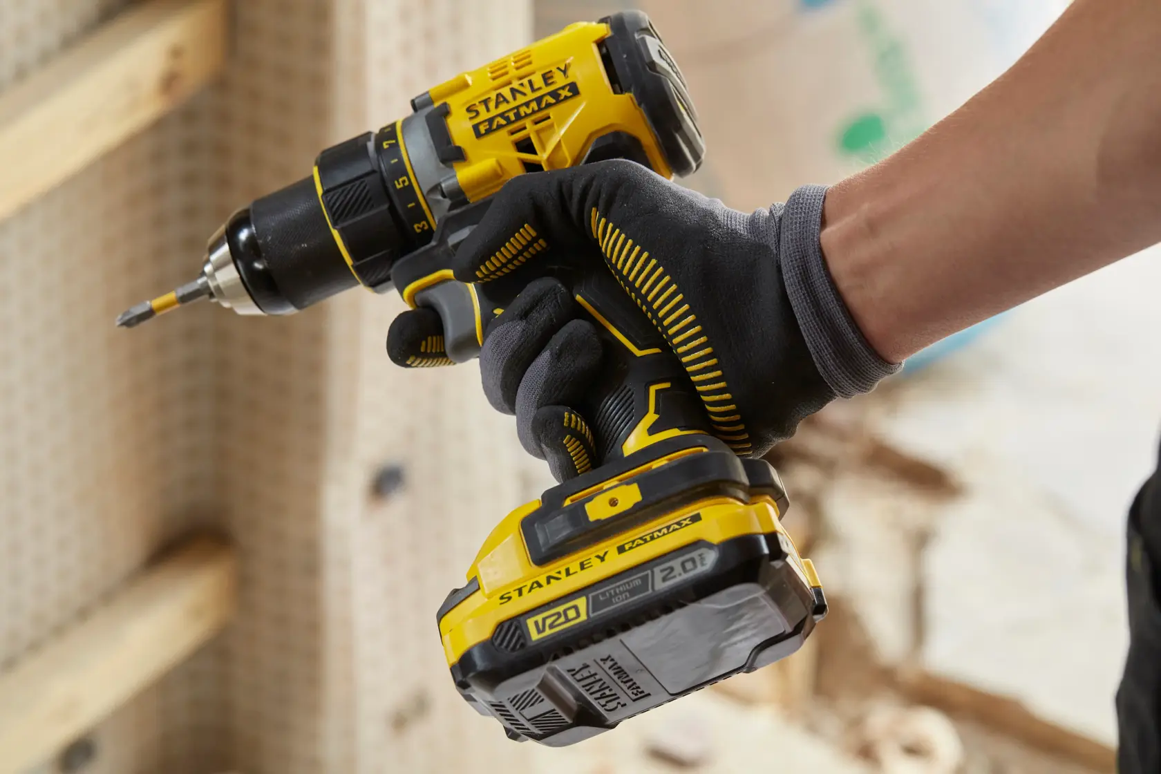 STANLEY SFMCD720D2K cordless drill photo showing yellow and black design held by gloved hand.