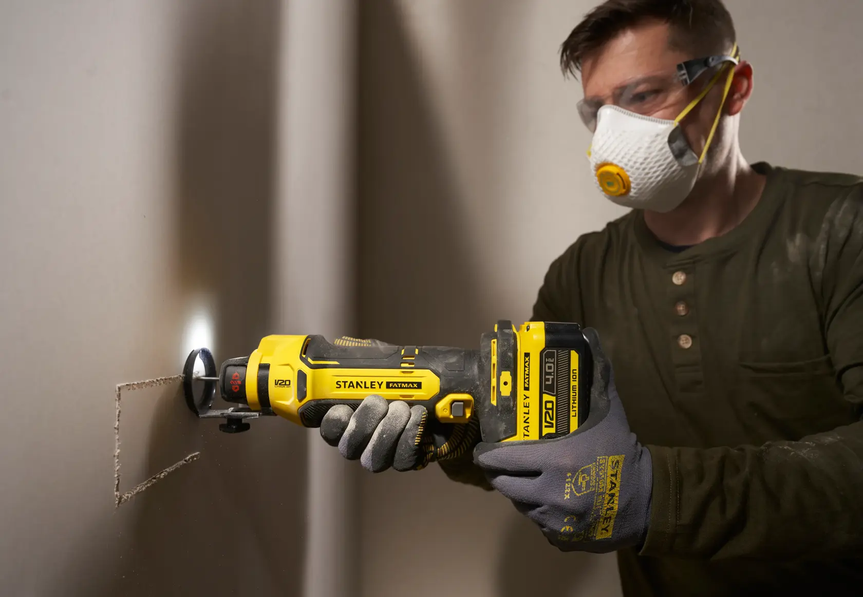 STANLEY SFMCE200B oszillierendes Multifunktionswerkzeug schneidet Gipskarton, Nahaufnahme seitliche Ansicht.
